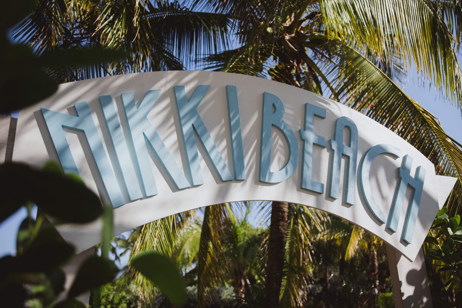 Nikki Beach Miama sign post surrounded by palm trees
