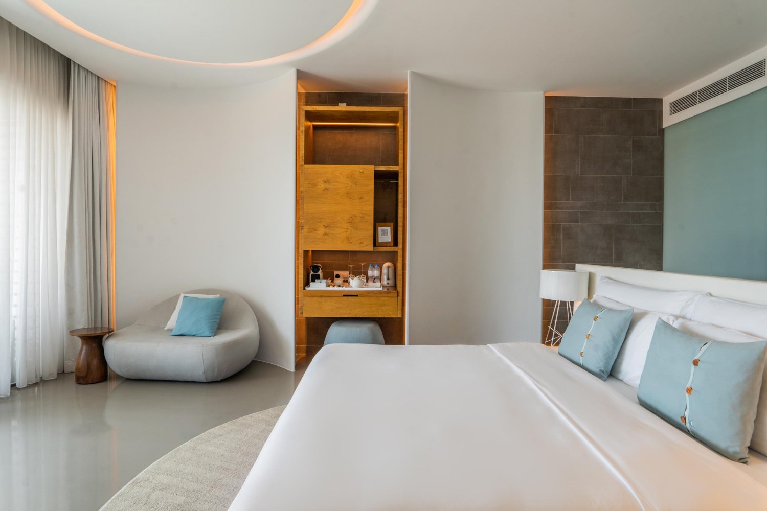 King sized bed with a small counter of glasses, water and coffee