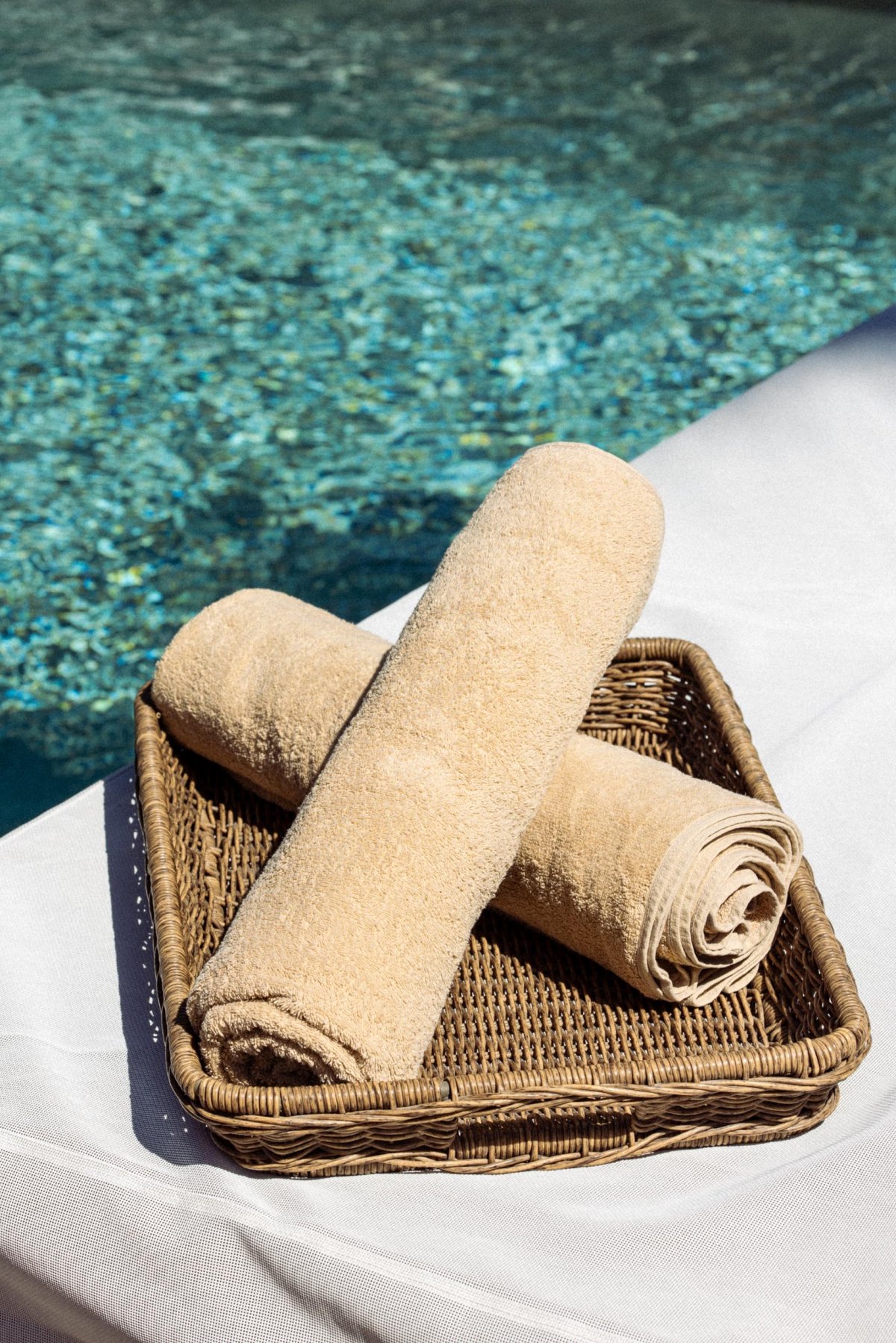 Two towels on a tray next to a pool