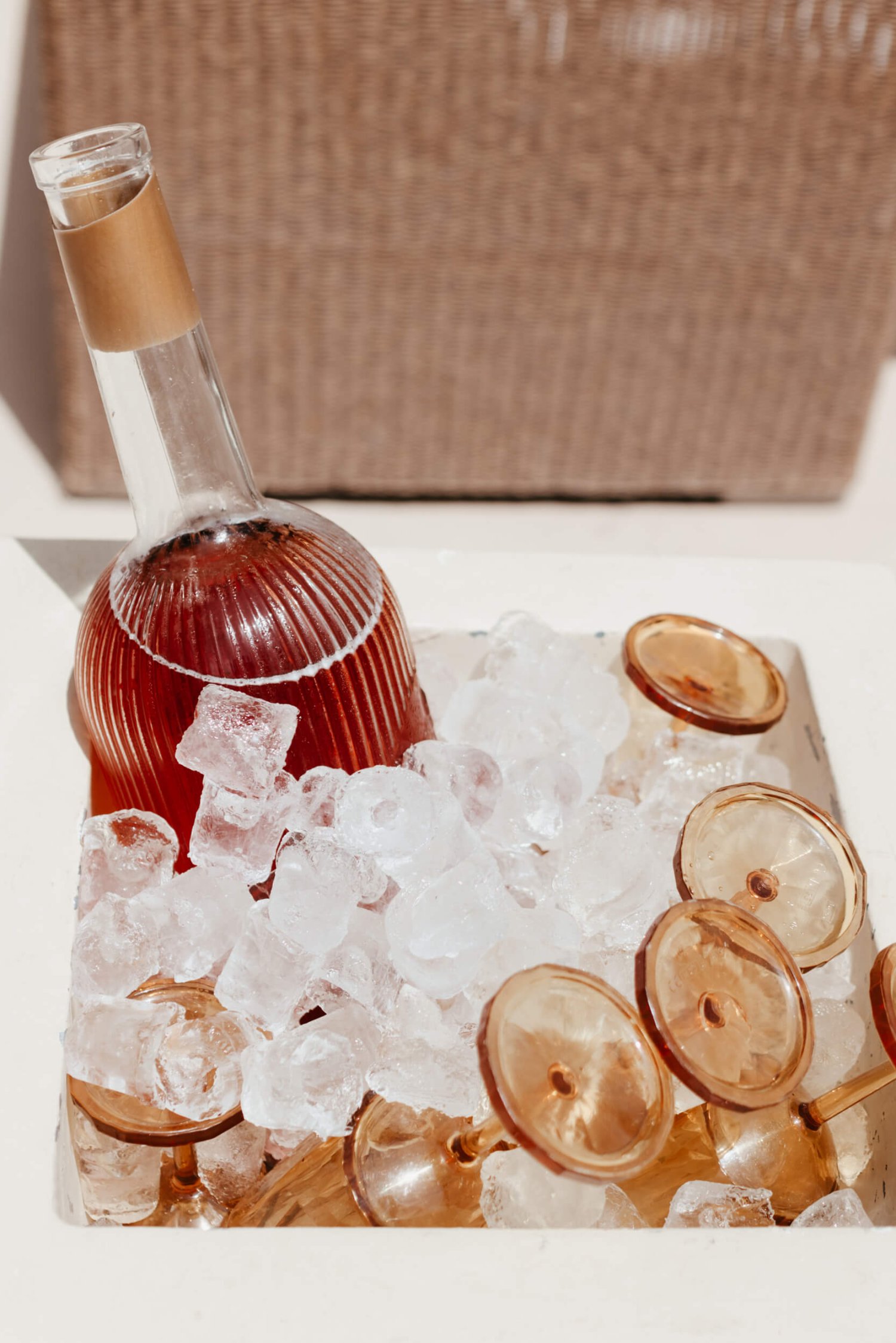 Bottle of wine and glasses in a big container of ice