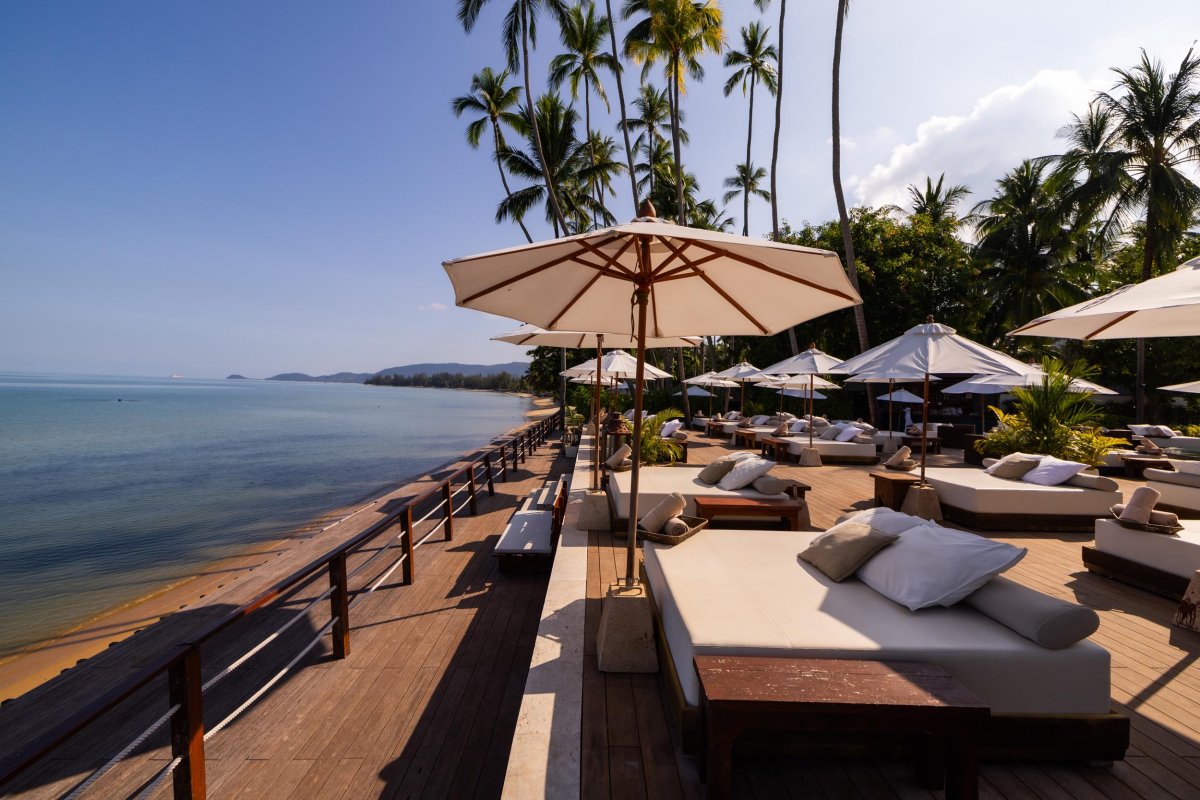 sun beds and umbrellas with a decking area separating to the beach