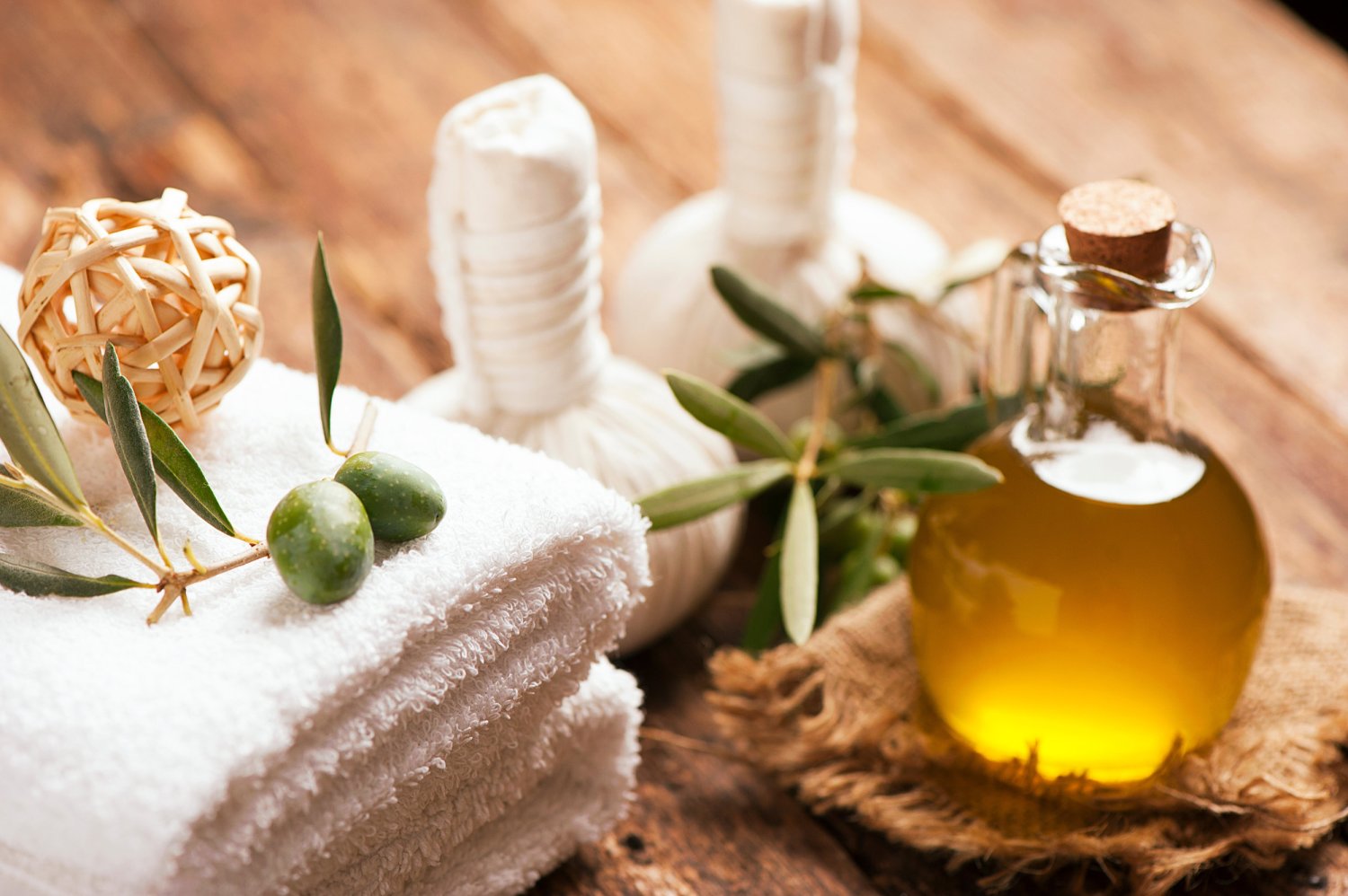 Olive oil in a bottle next to folded towels