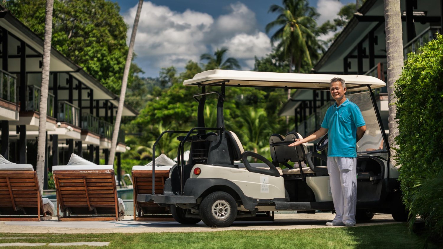 A man standing next to a small buggy welcoming guests