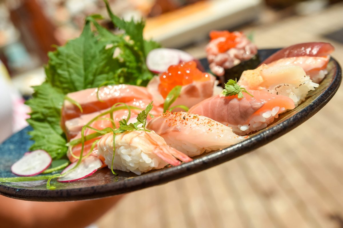 a close up image of a plate of garnished sushi including shrimp