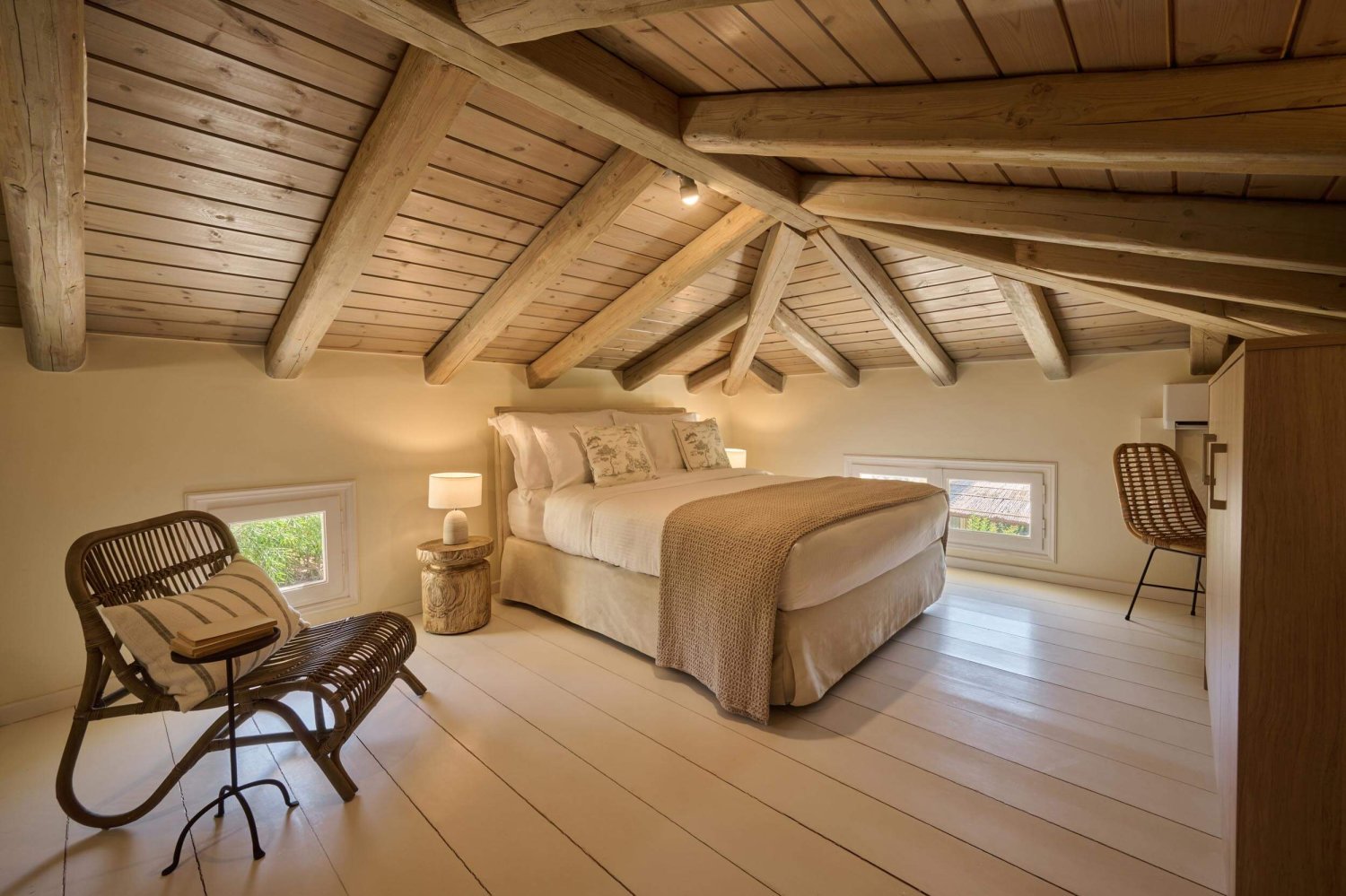 king size bed in bedroom with arm chair, wardrobe and desk