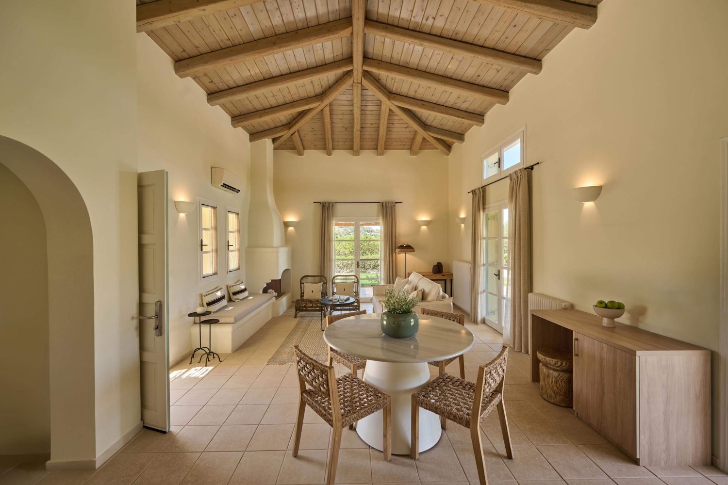 Living/ dining area featuring sofas, arm chairs, fireplace, cabinets and a small round dining table