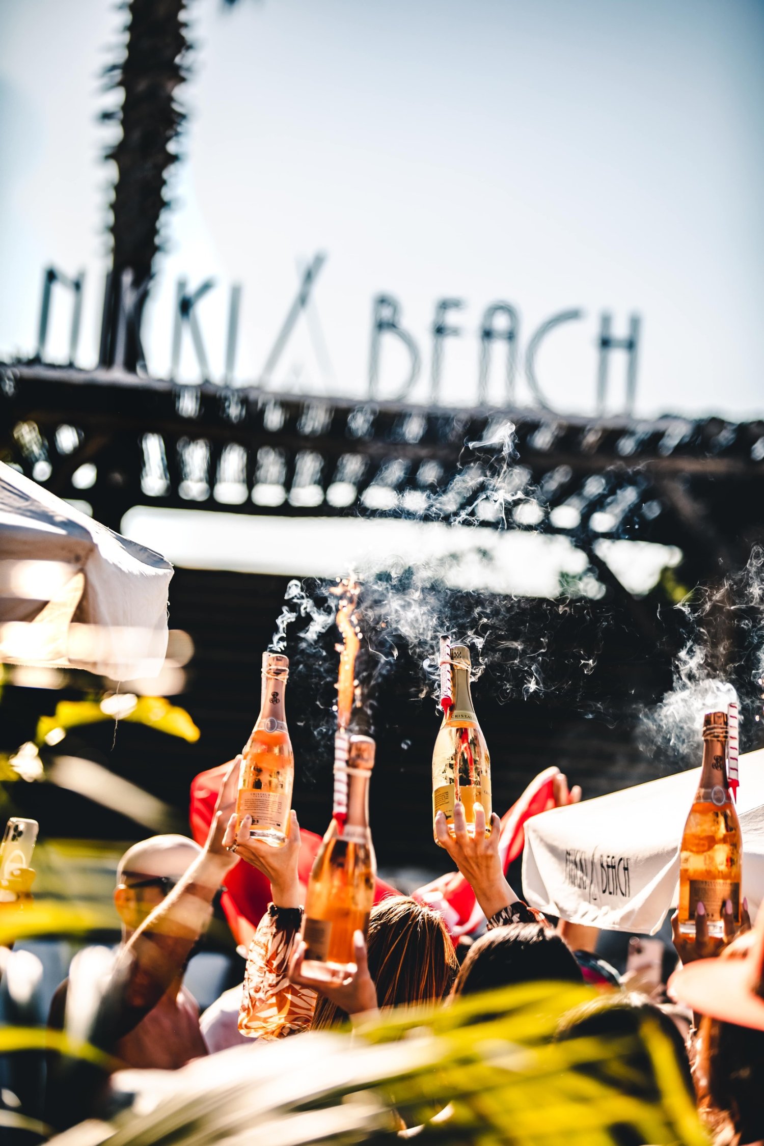 A vibrant summer party at Nikki Beach, featuring sun-soaked guests, elegant decor, and lively music by the ocean.