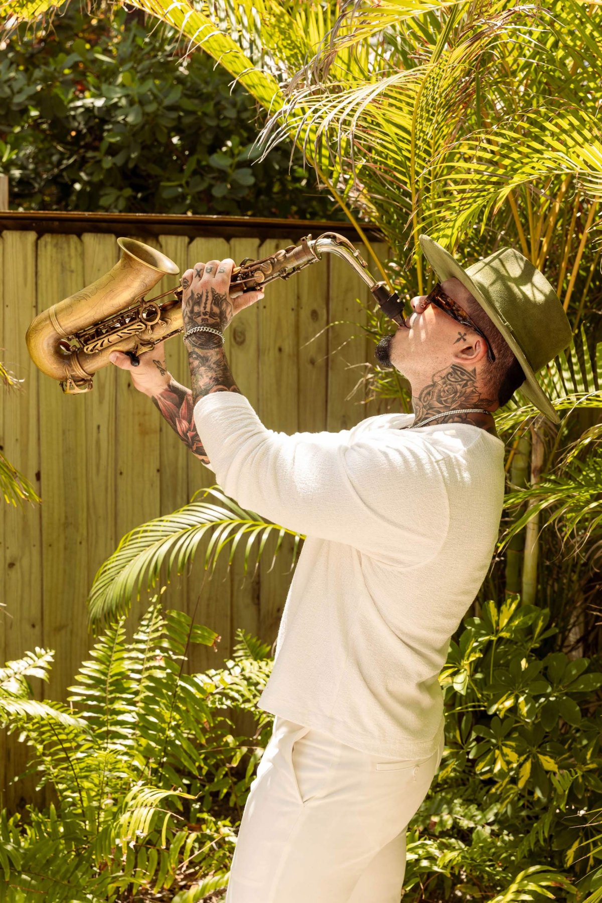 a man playing the saxophone, holding the sax up in the air