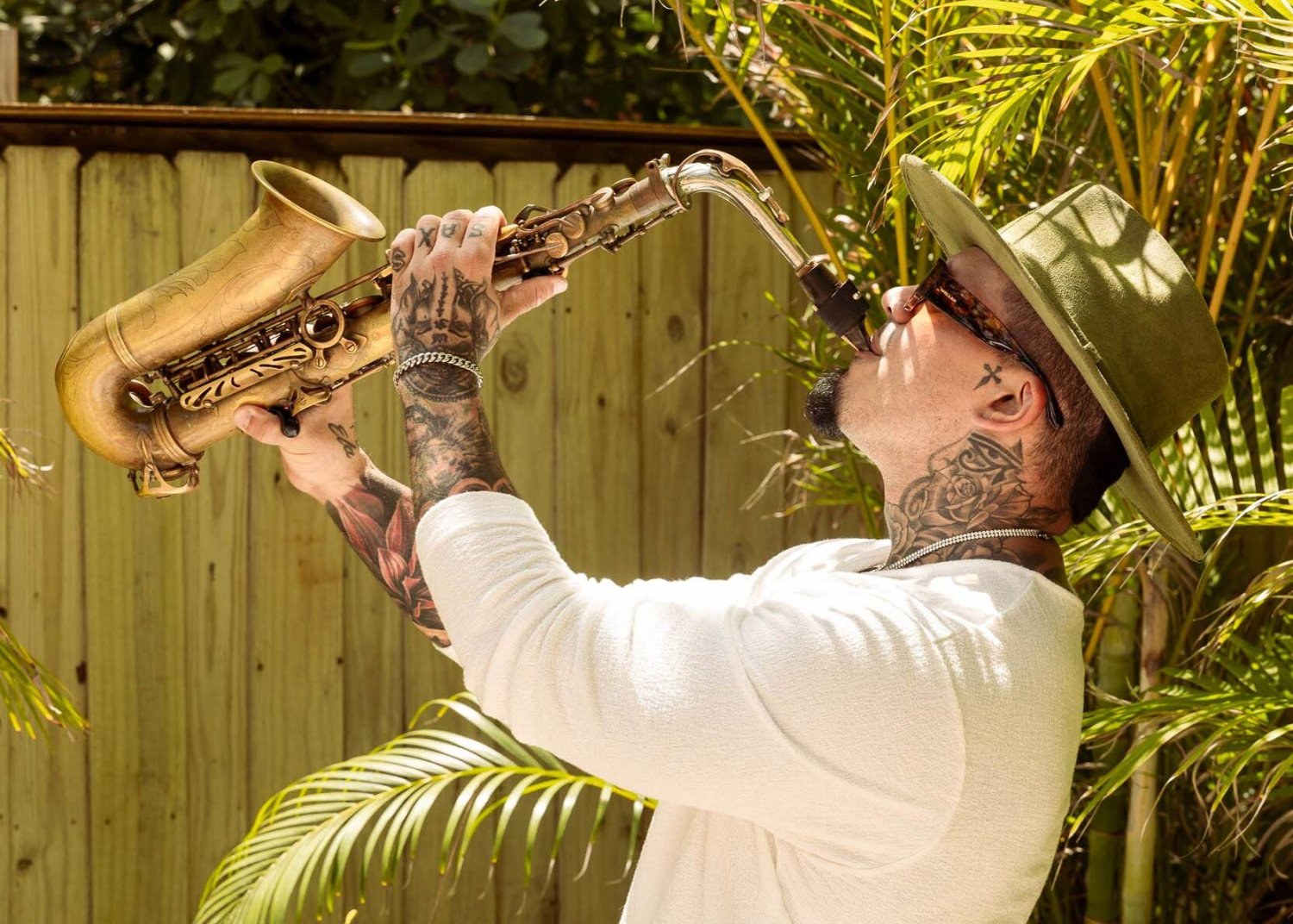 a man playing the saxophone, holding the sax up in the air