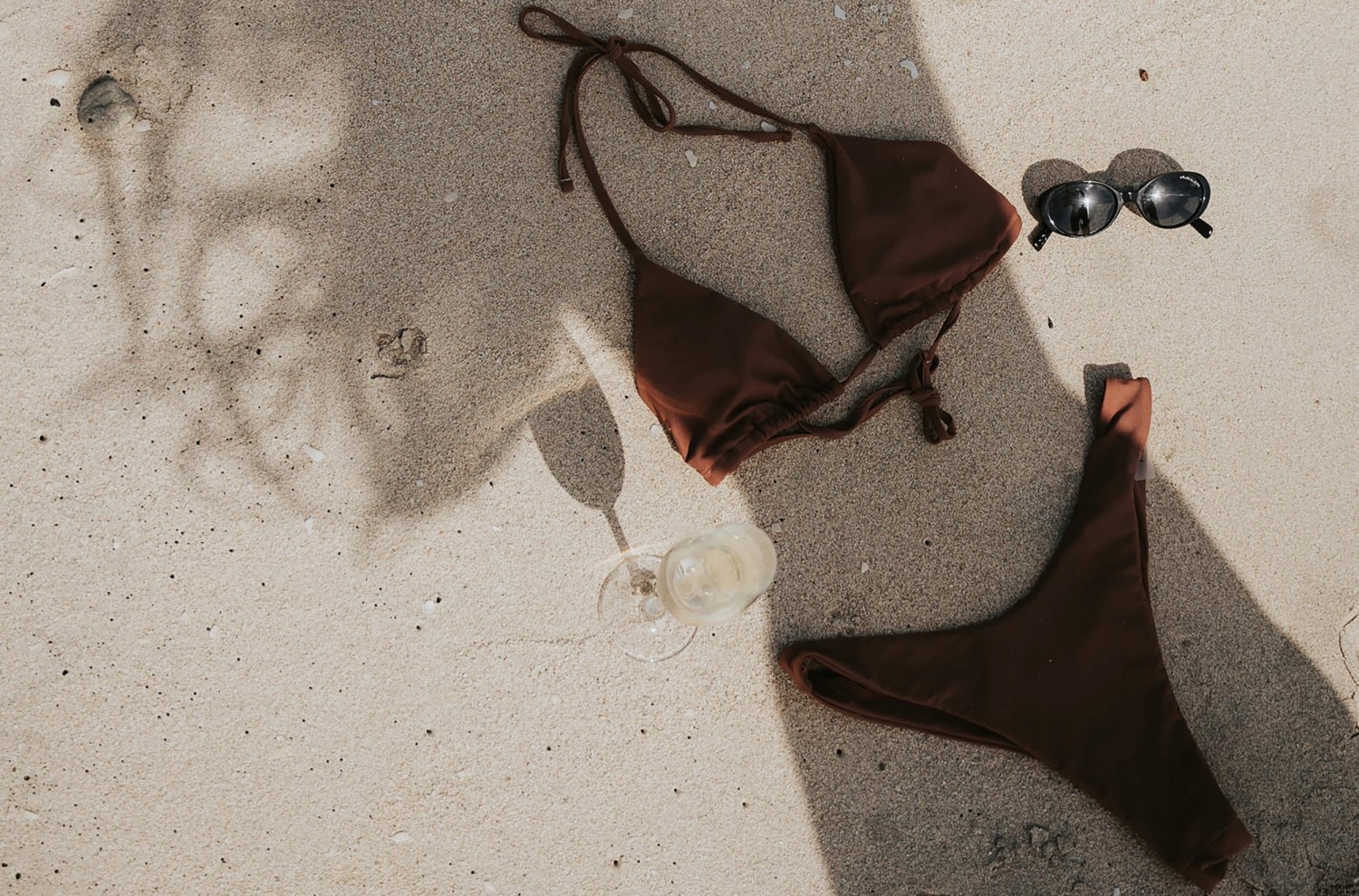 Artistic swimsuit in the sand with sunglasses