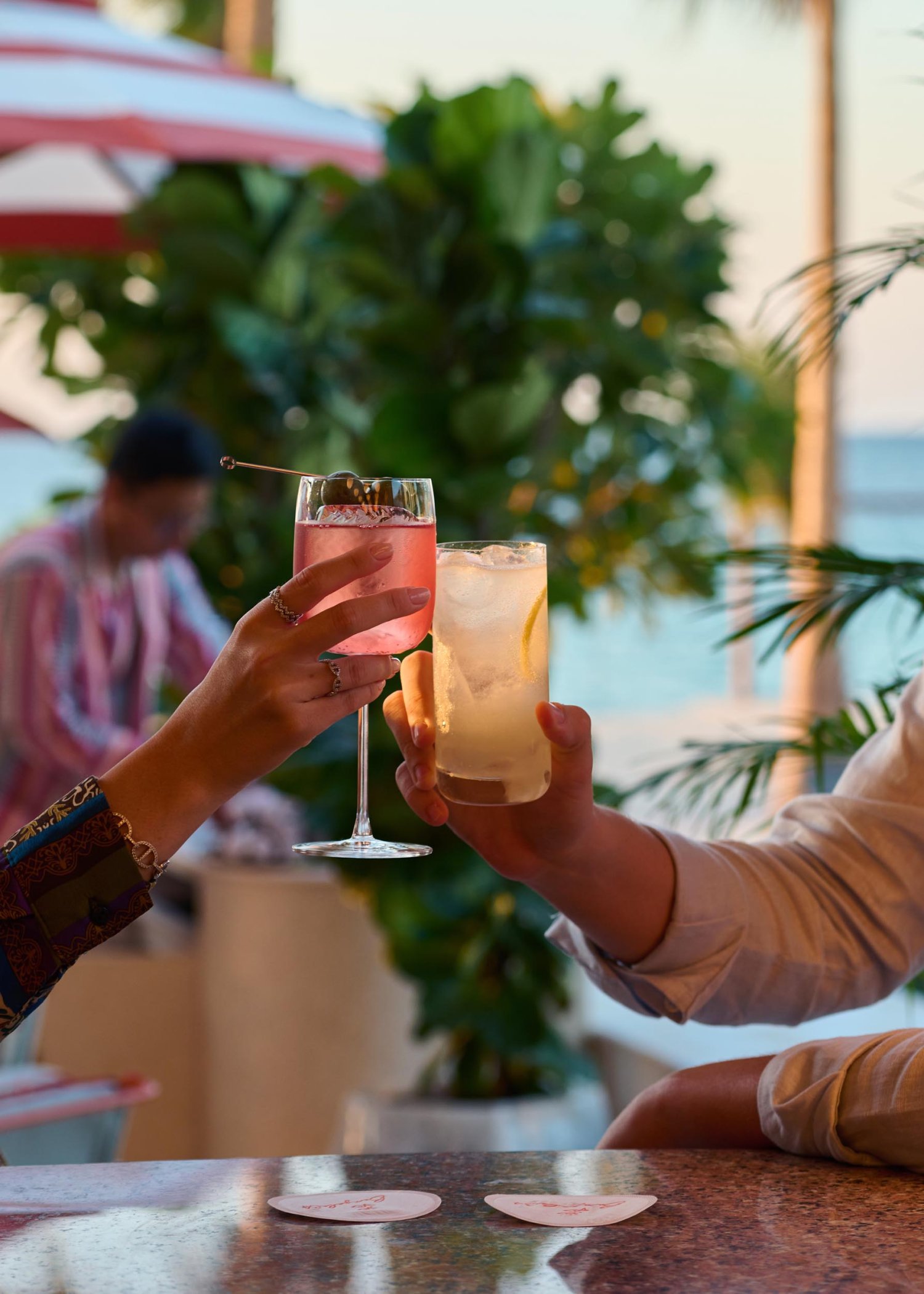 Two people cheersing cocktails