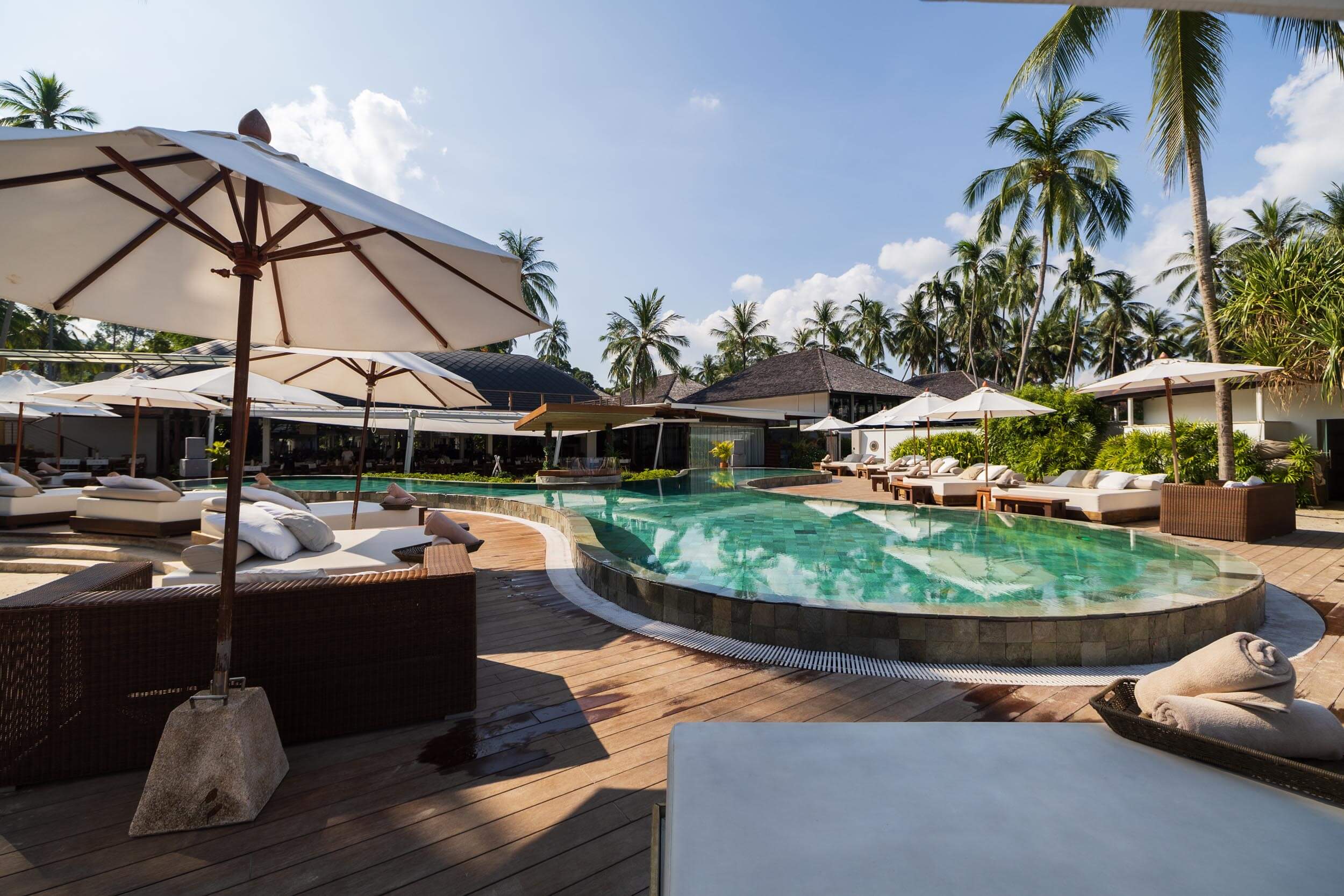 Infinity pool surrounded by sun beds and umbrellas