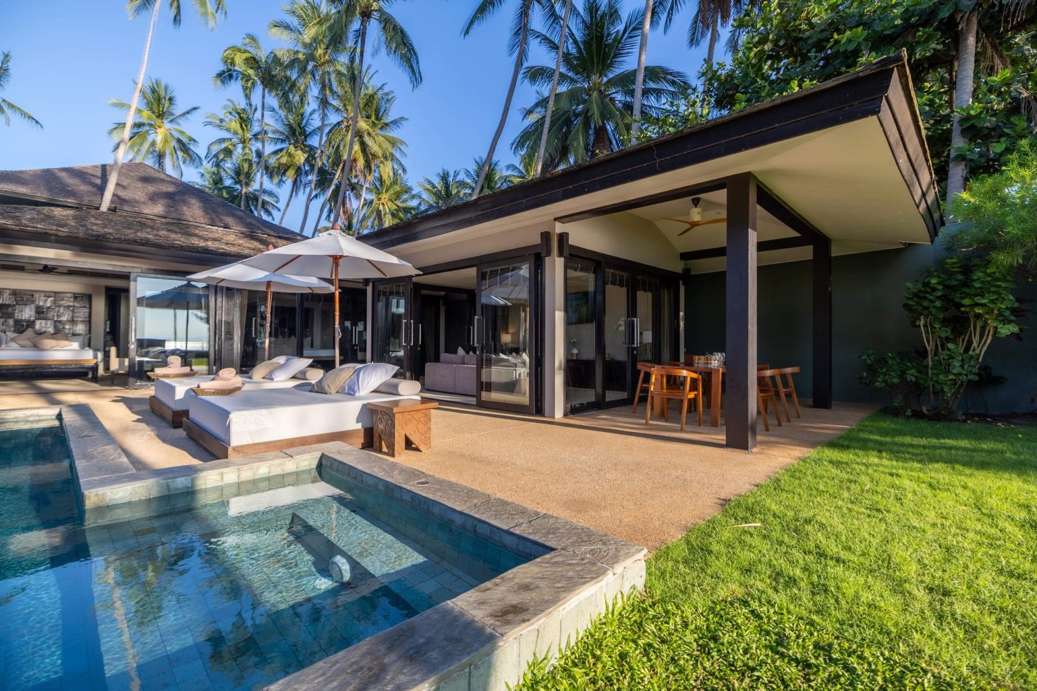 private garden of villa with pool, sun beds and outdoor dining area