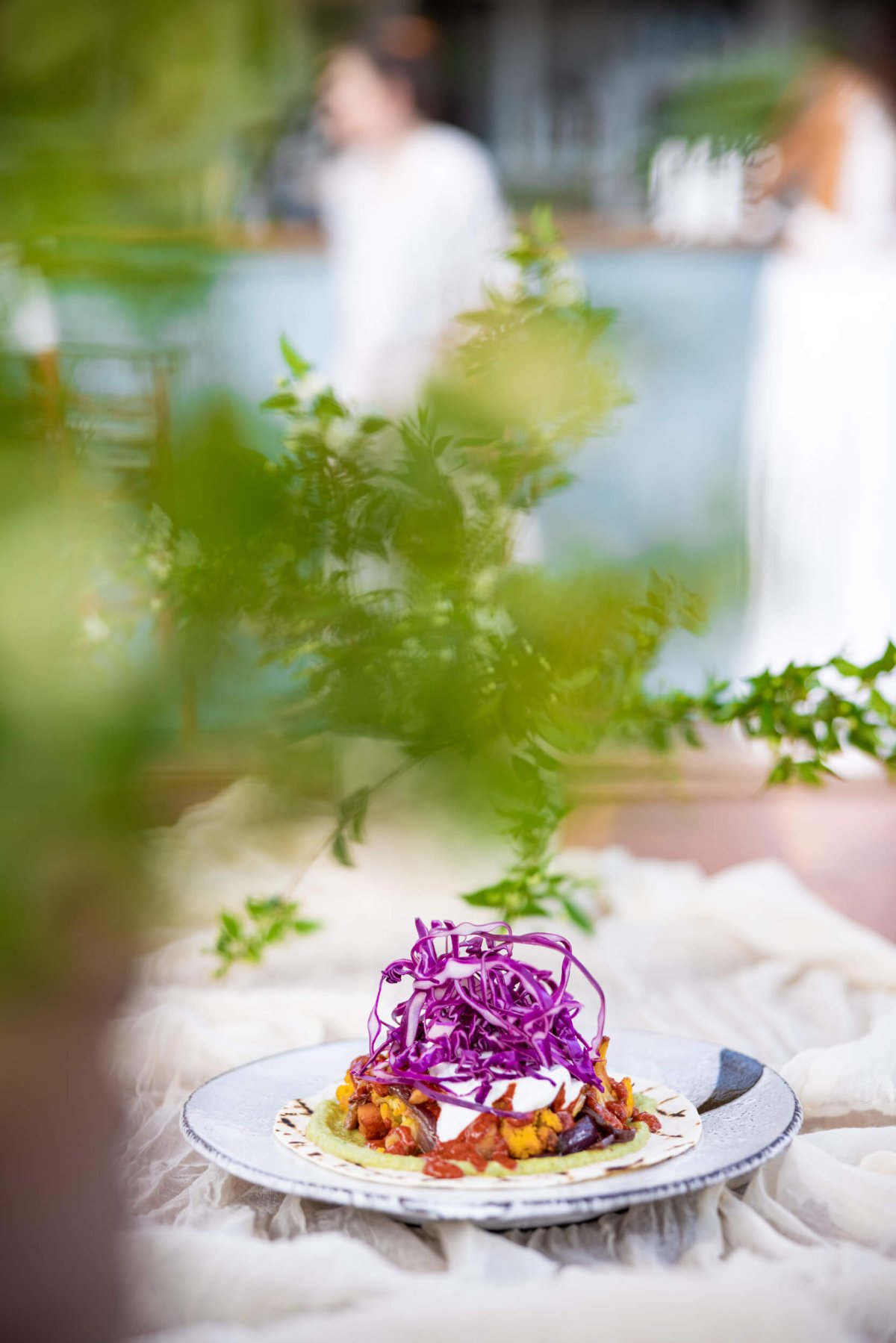 Plate of food with garnish and leaves in the foreground