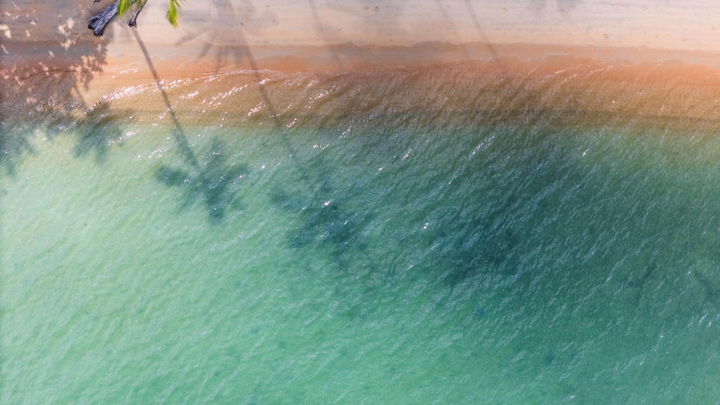 Ariel shot of a sandy beach and blue sea