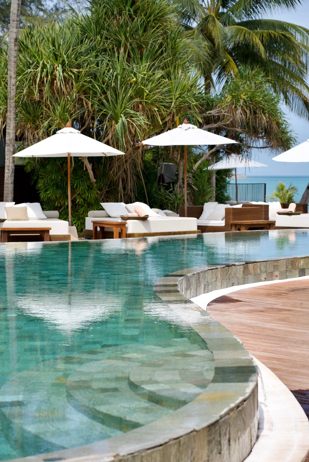 Infinity pool surrounded by sun beds and umbrellas