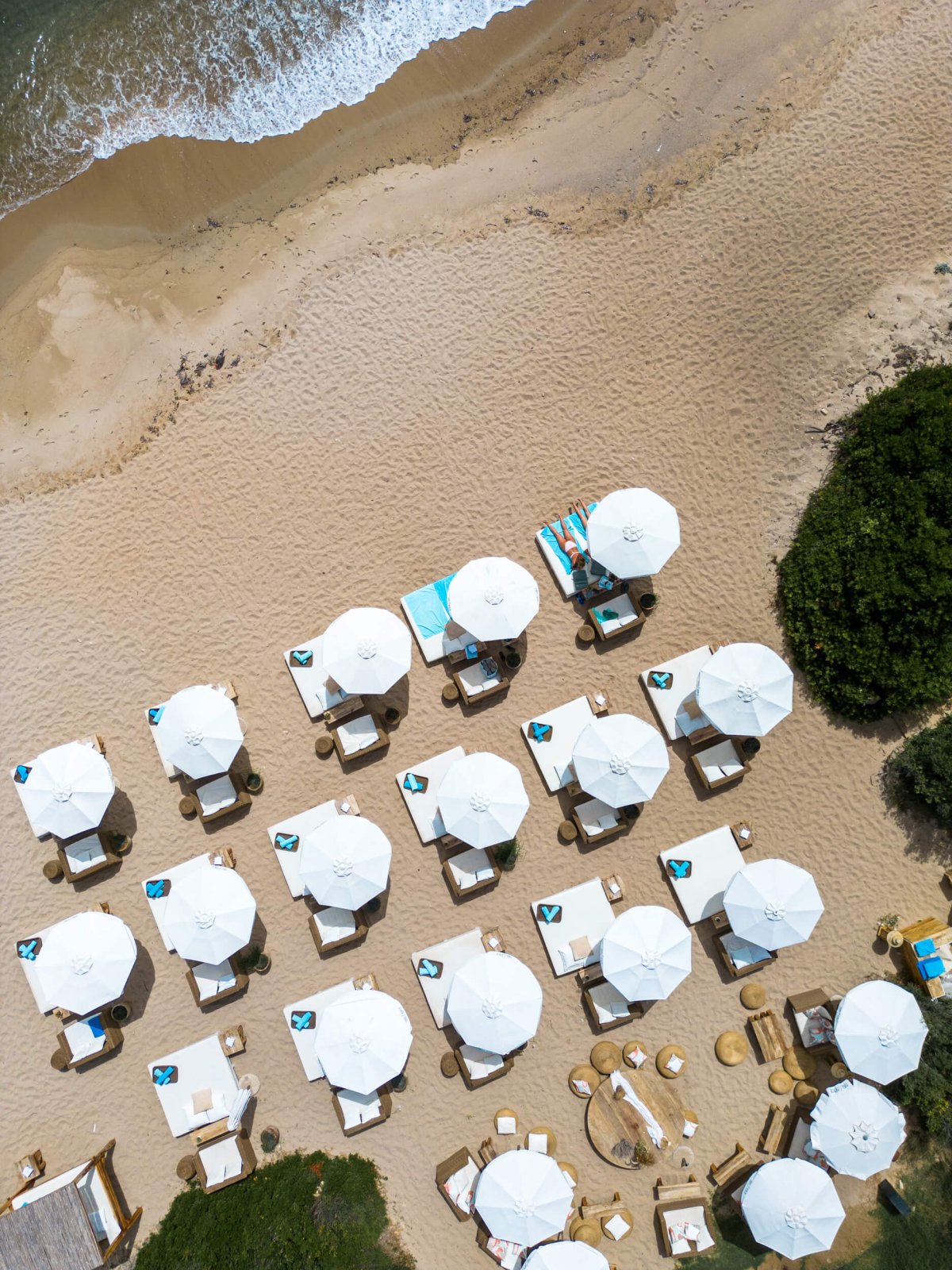 Drone shot of several sun loungers on the beach