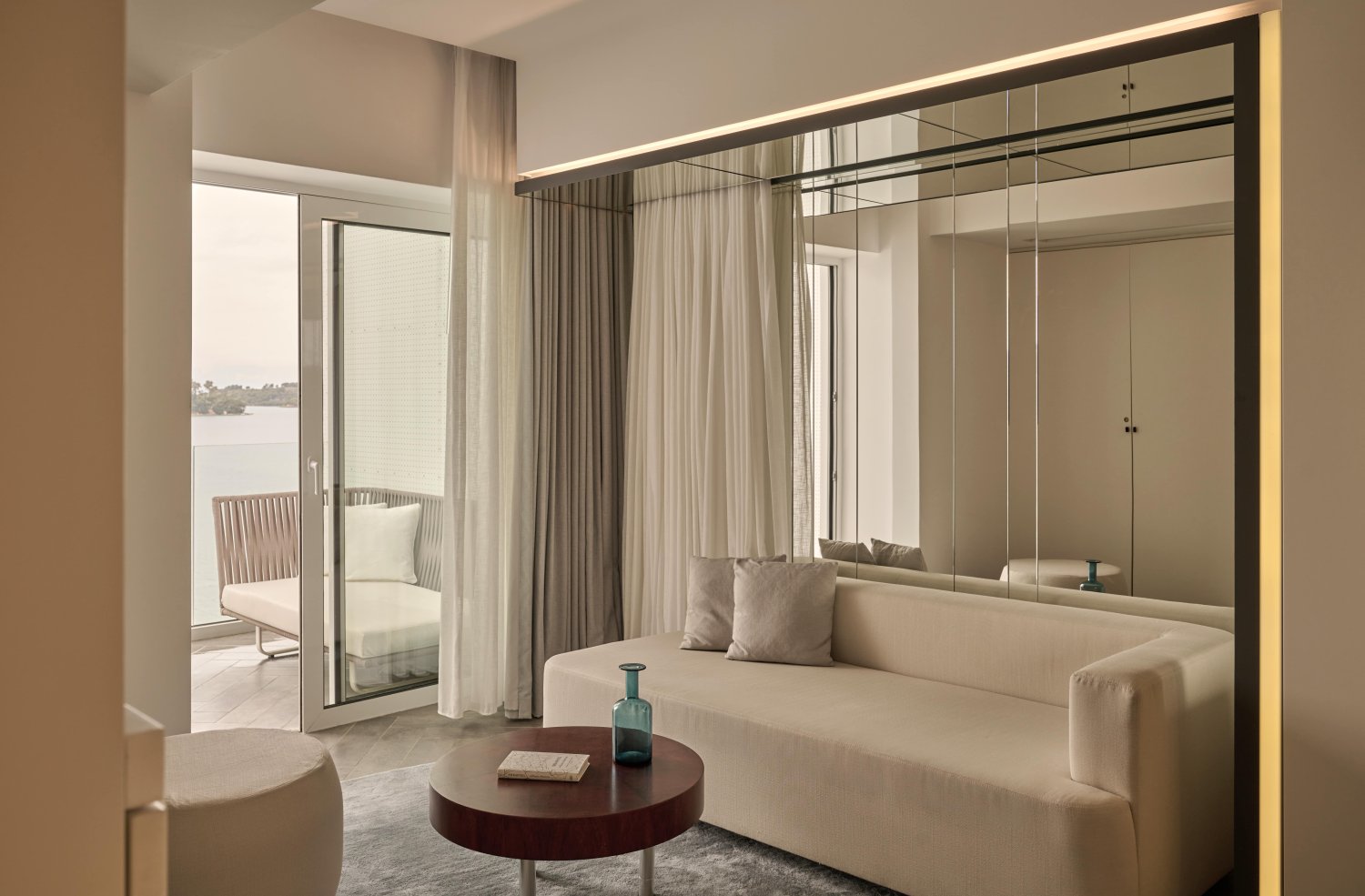 A chic modern room featuring a stylish couch and a large mirror, exuding elegance and comfort