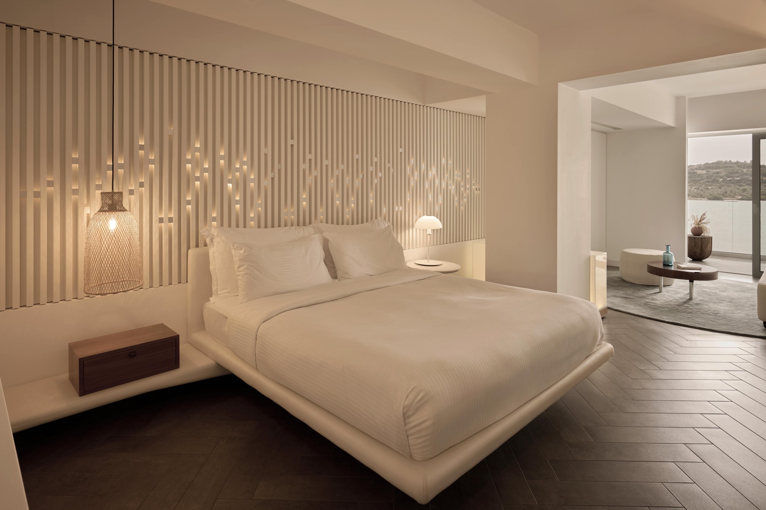 Elegant bedroom featuring a plush bed and a stunning view of tranquil waters through large windows