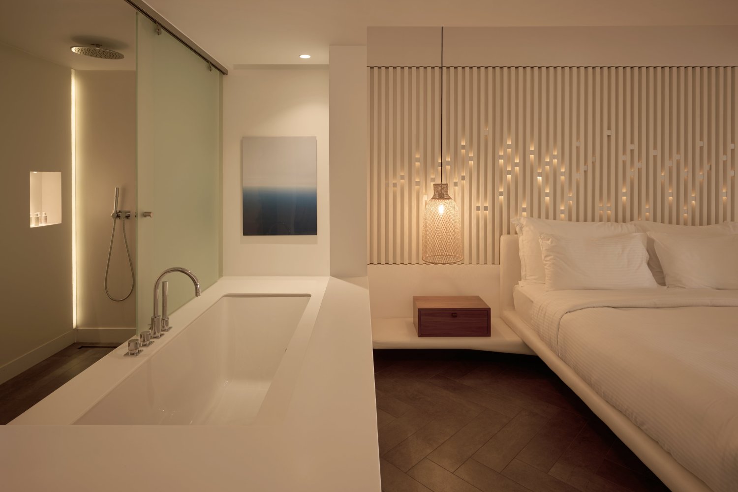 A contemporary hotel room with a sumptuous bed and a refined bathtub, embodying luxury and comfort in every detail