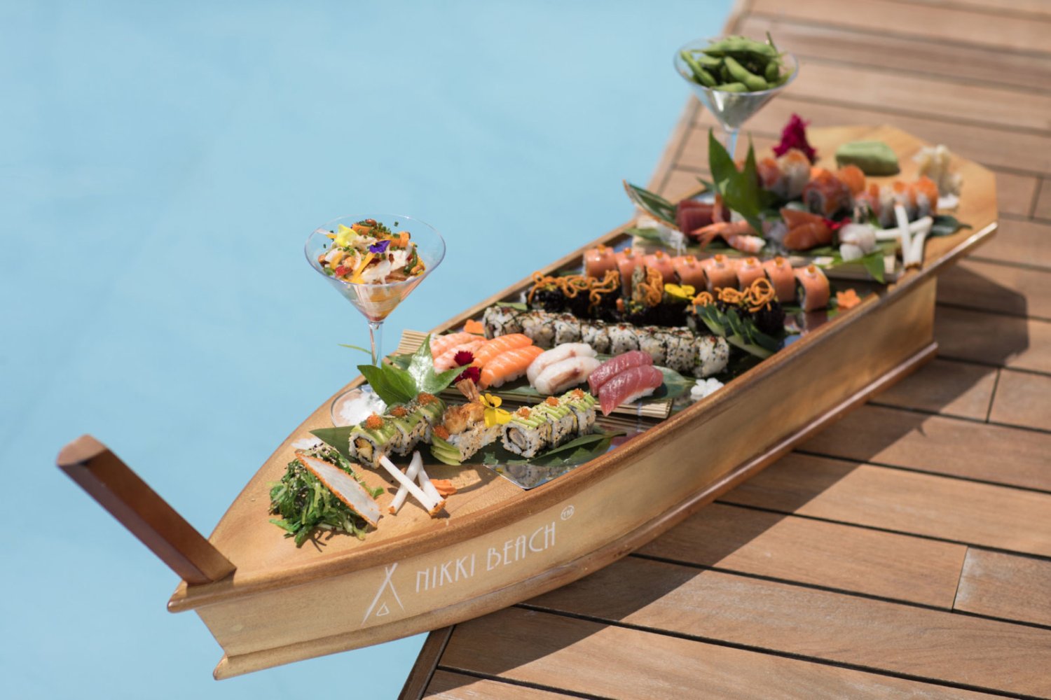 A platter of seafood served on a wooden, boat shaped board