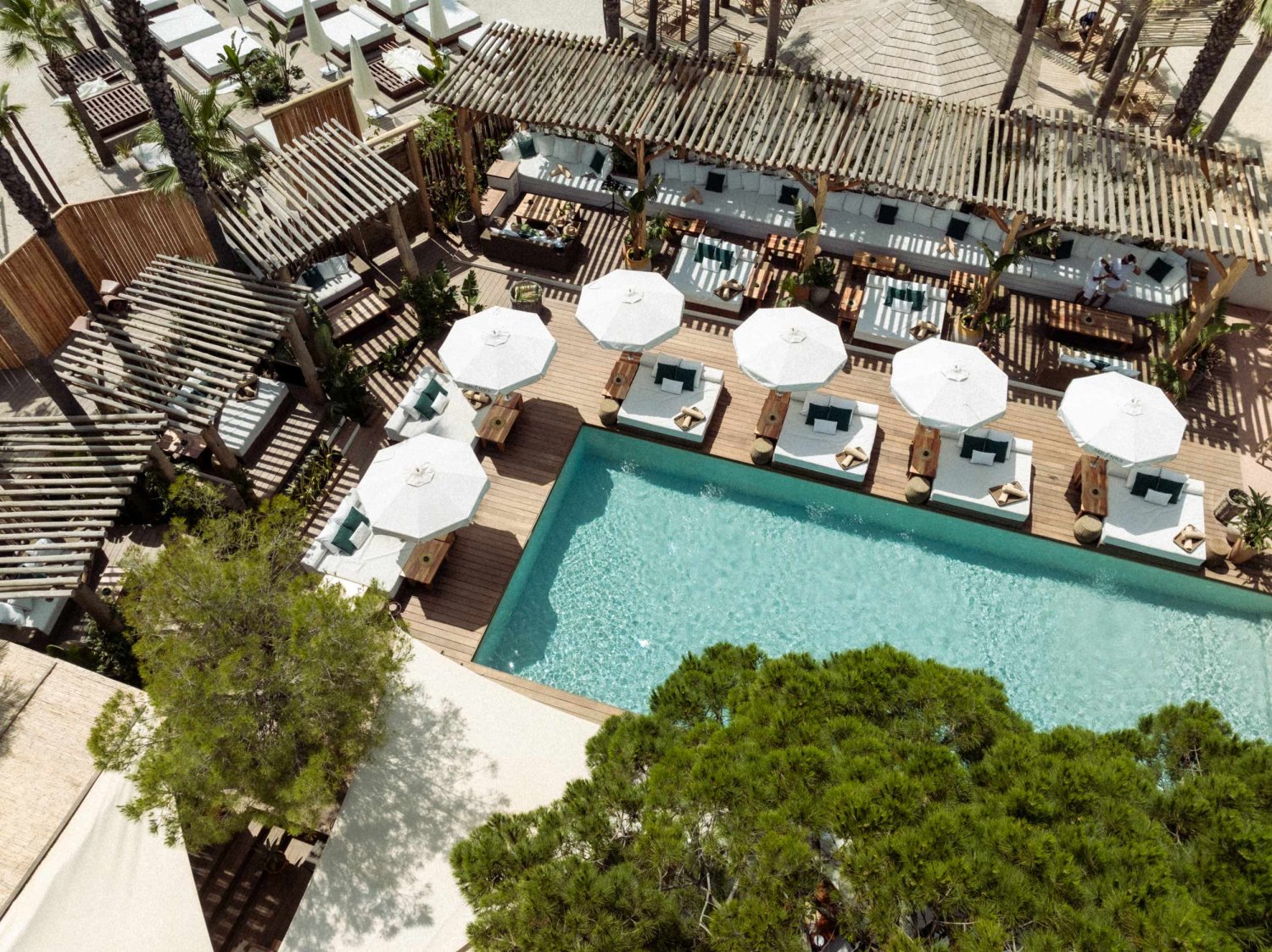 Birds eye view of corner of a pool area with sunbeds and umbrellas