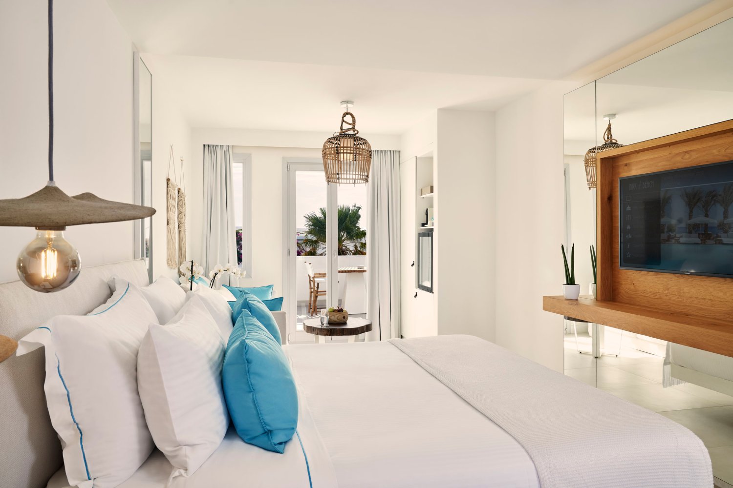 Signature room: double bed and tv with doors onto patio area