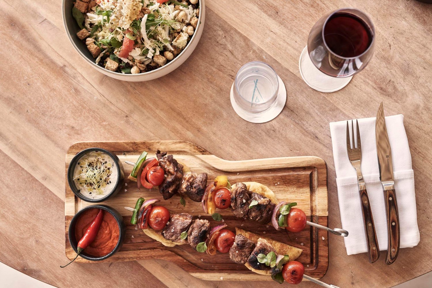 Meat skewers with mediterranean vegetables served on a wooden board