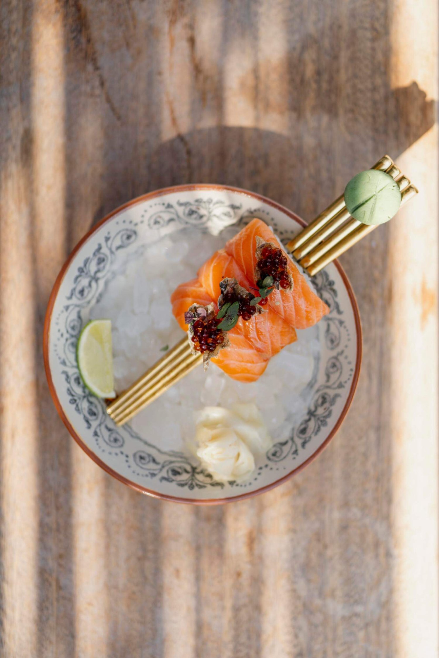 Sliced salmon served on chopsticks