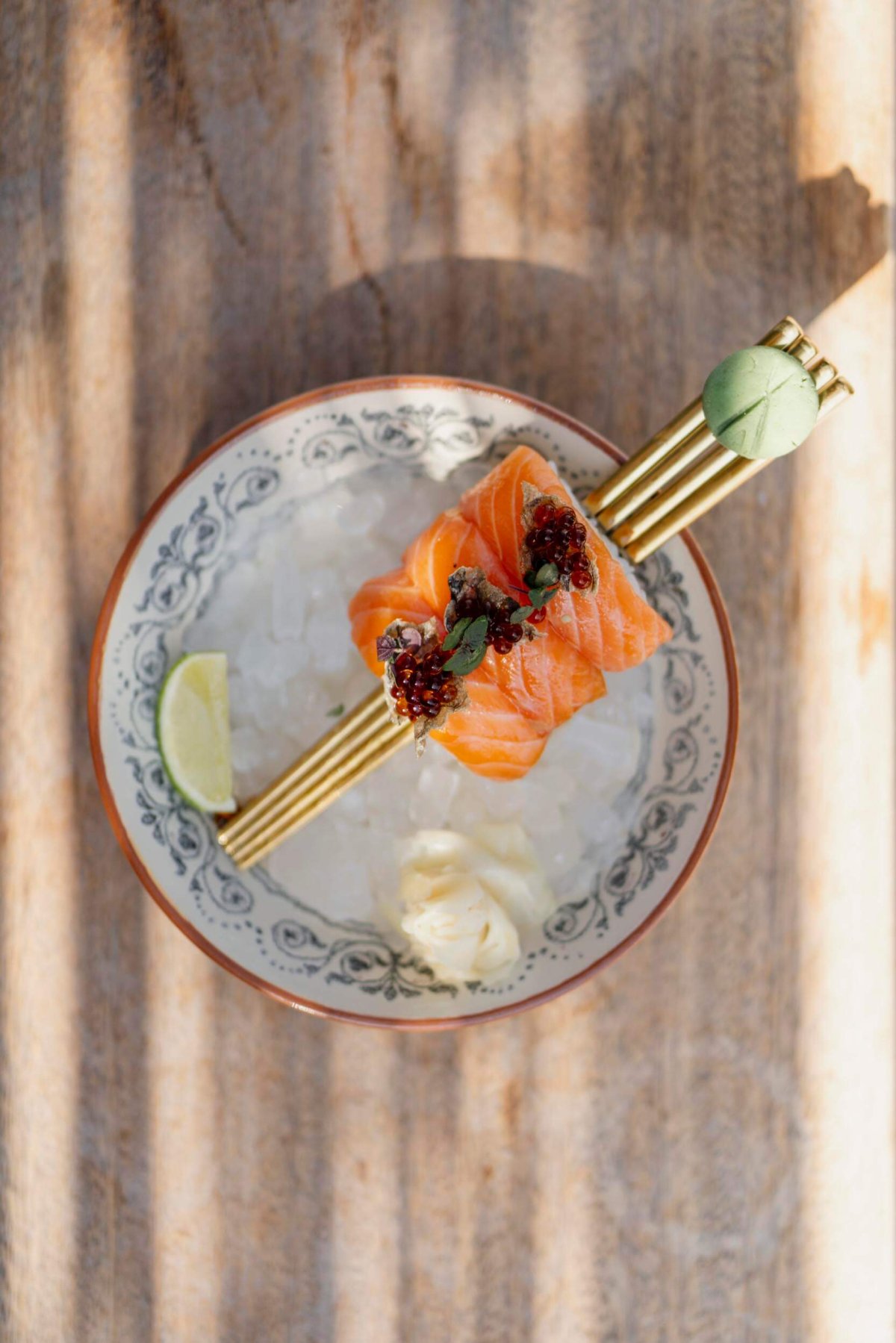 Sliced salmon served on chopsticks