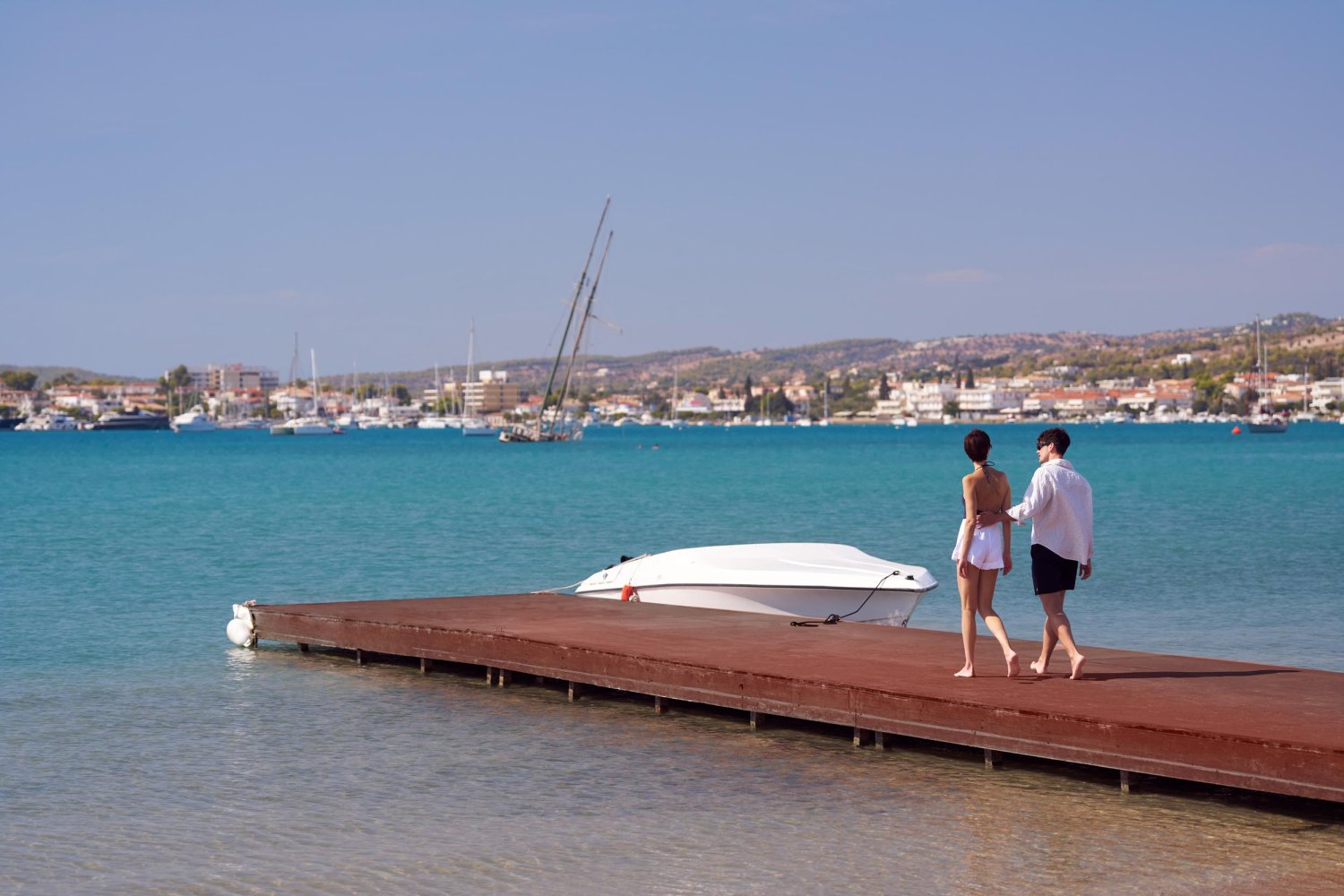 A couple walking along a boat dock