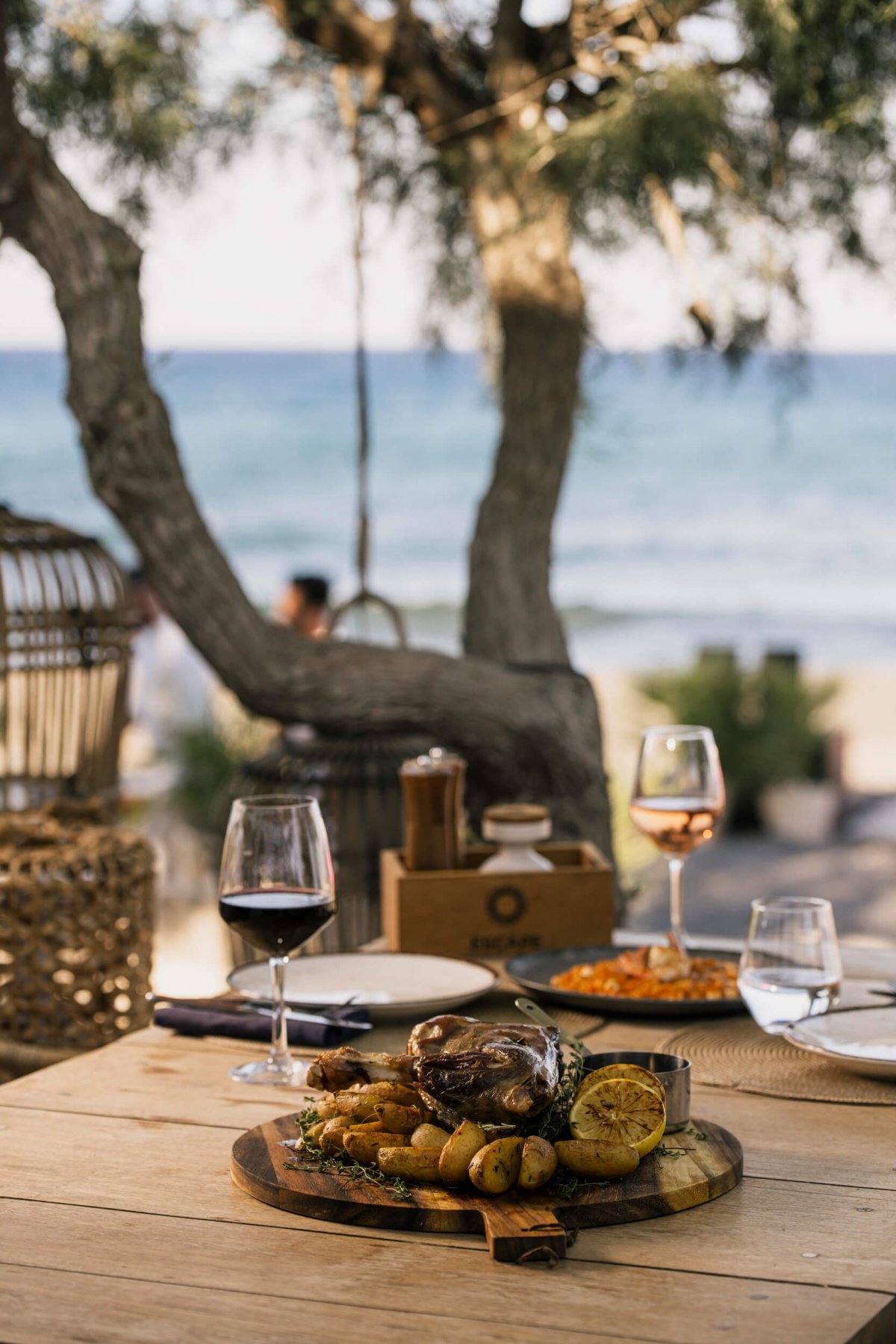 Close up of a sharing dish on a wooden tablr with two glasses of wine