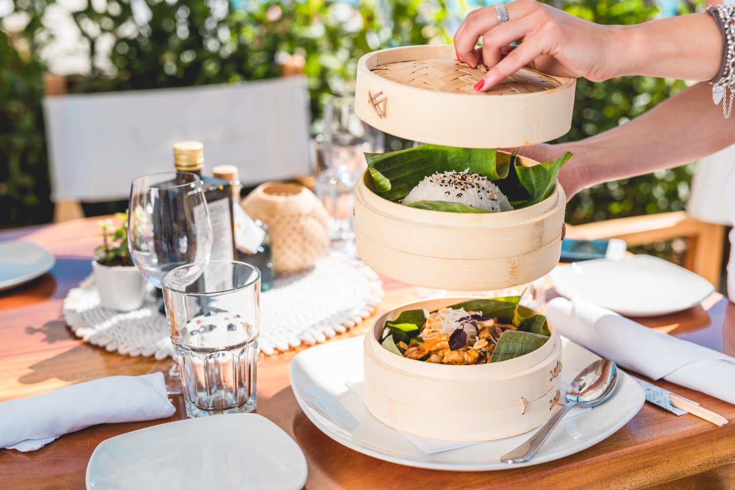 bamboo steamers with crab dish and rice being opened onto a plate