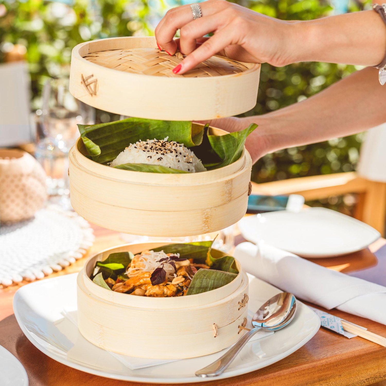 bamboo steamers with crab dish and rice being opened onto a plate