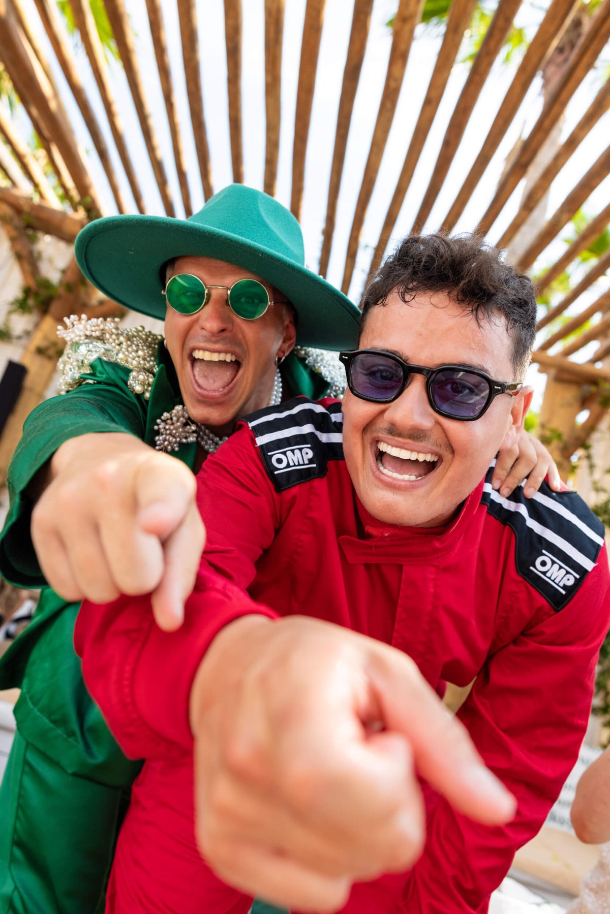 Two men in fancy dress smiling and pointing at the camera