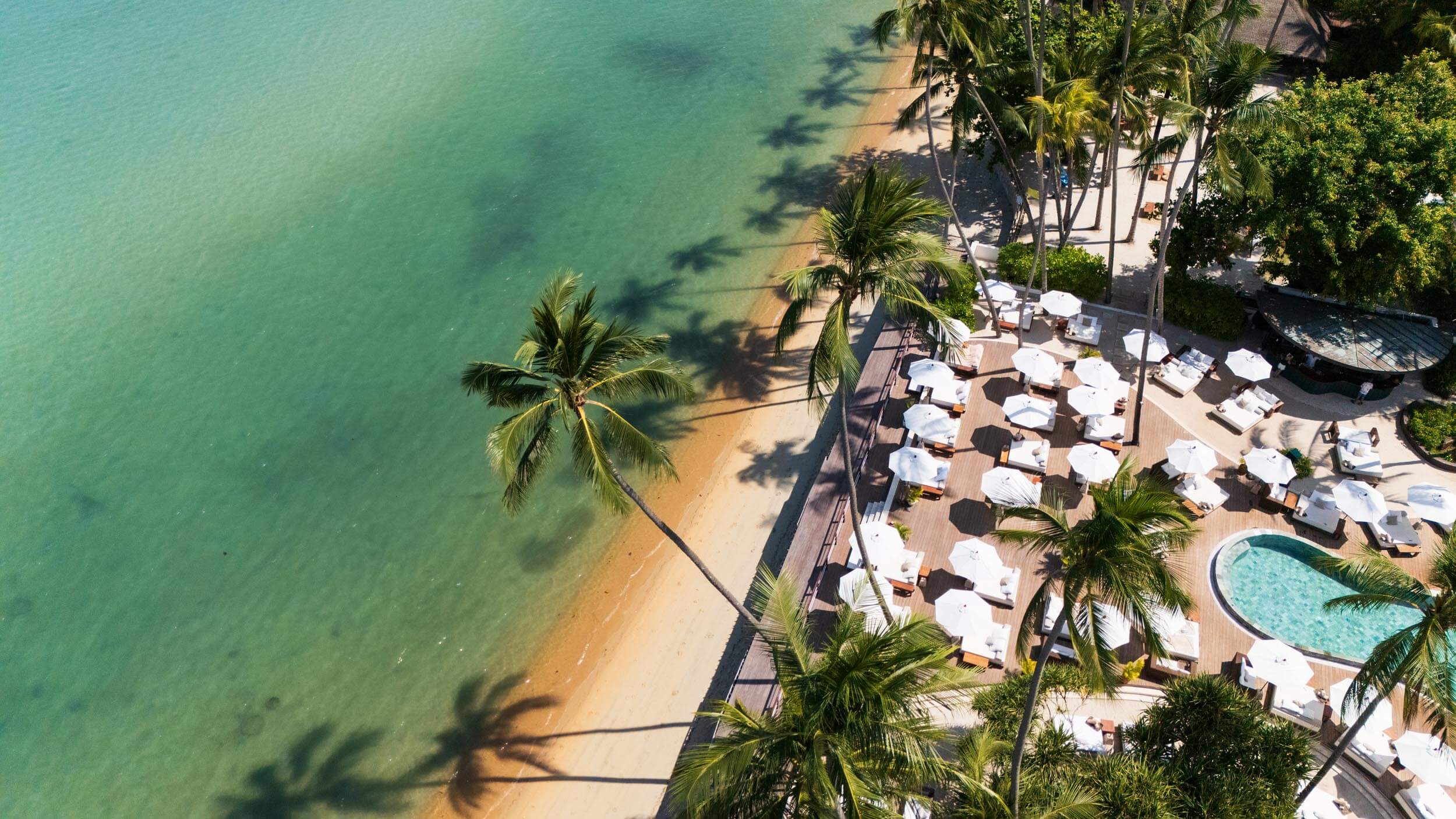 Ariel shot of Nikki Beach pool area next to the sandy beach and sea