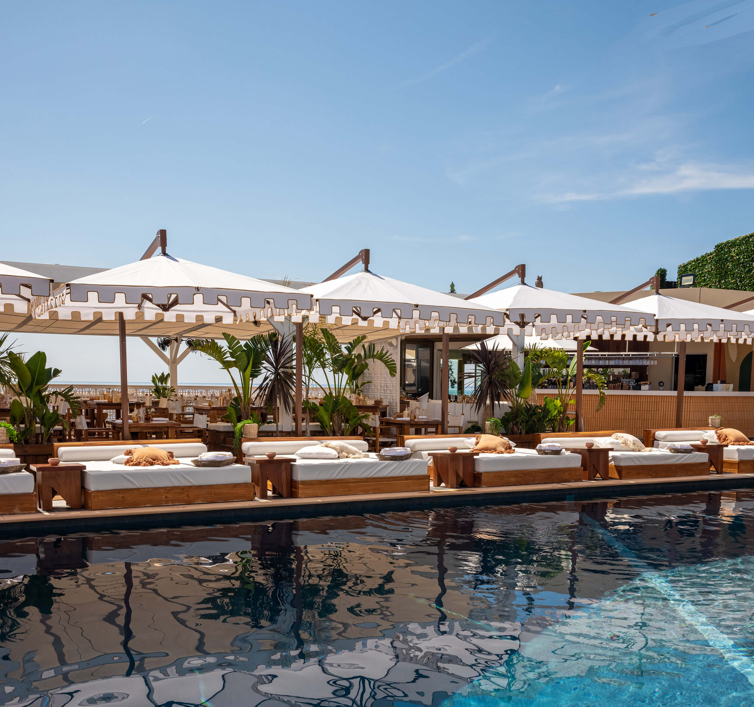 Sun beds with parasols at the side of a pool