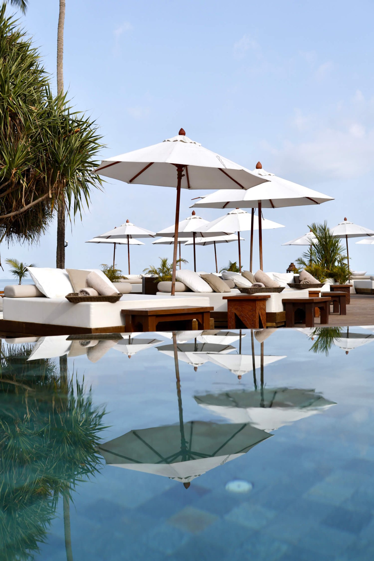 Sunbeds next to a pool with parasol