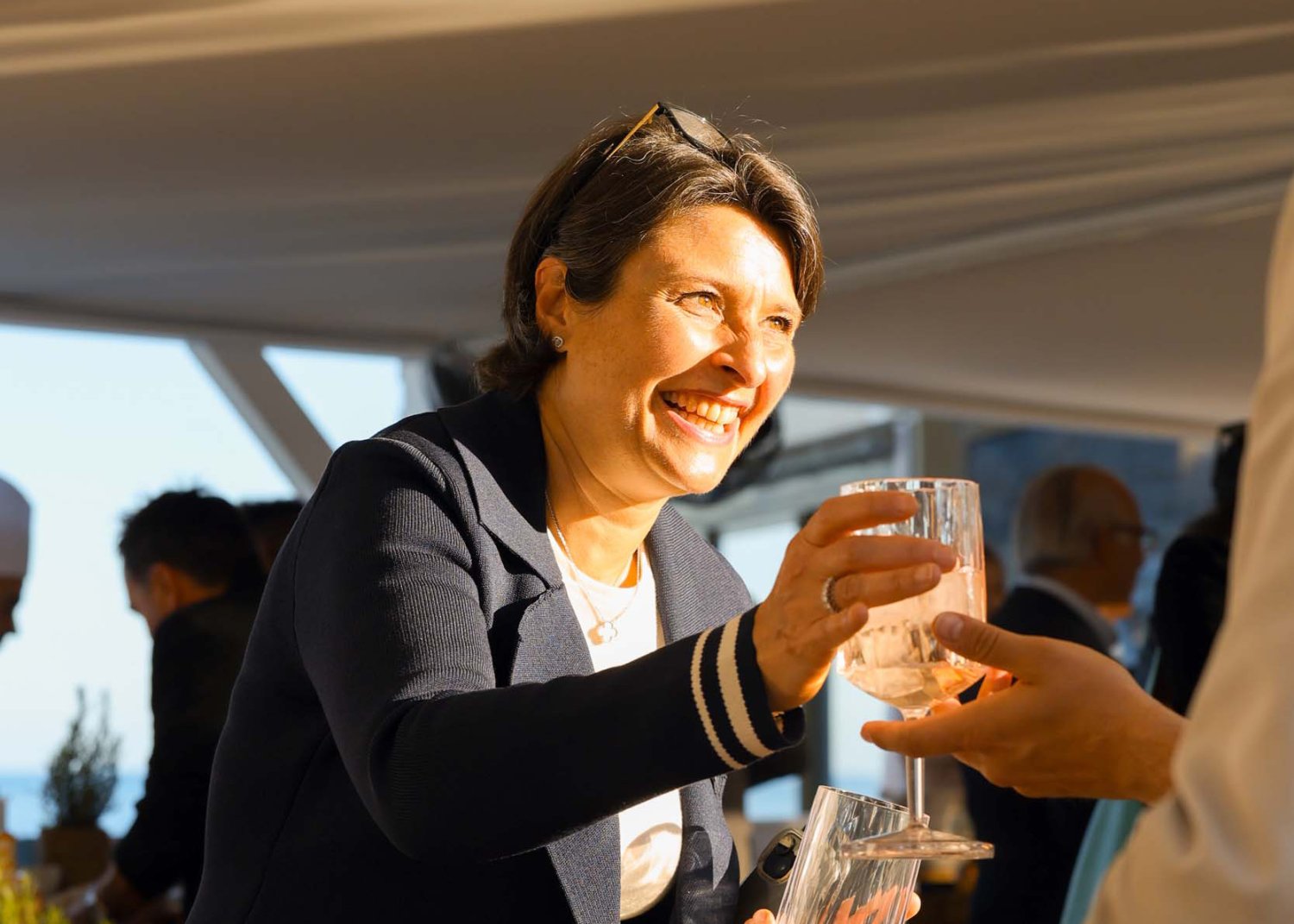 Lady serving drinks to guests, smiling