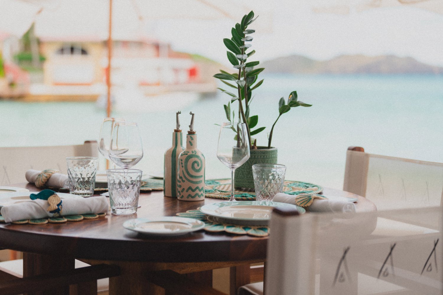A set dinner table with the sea visible in the background