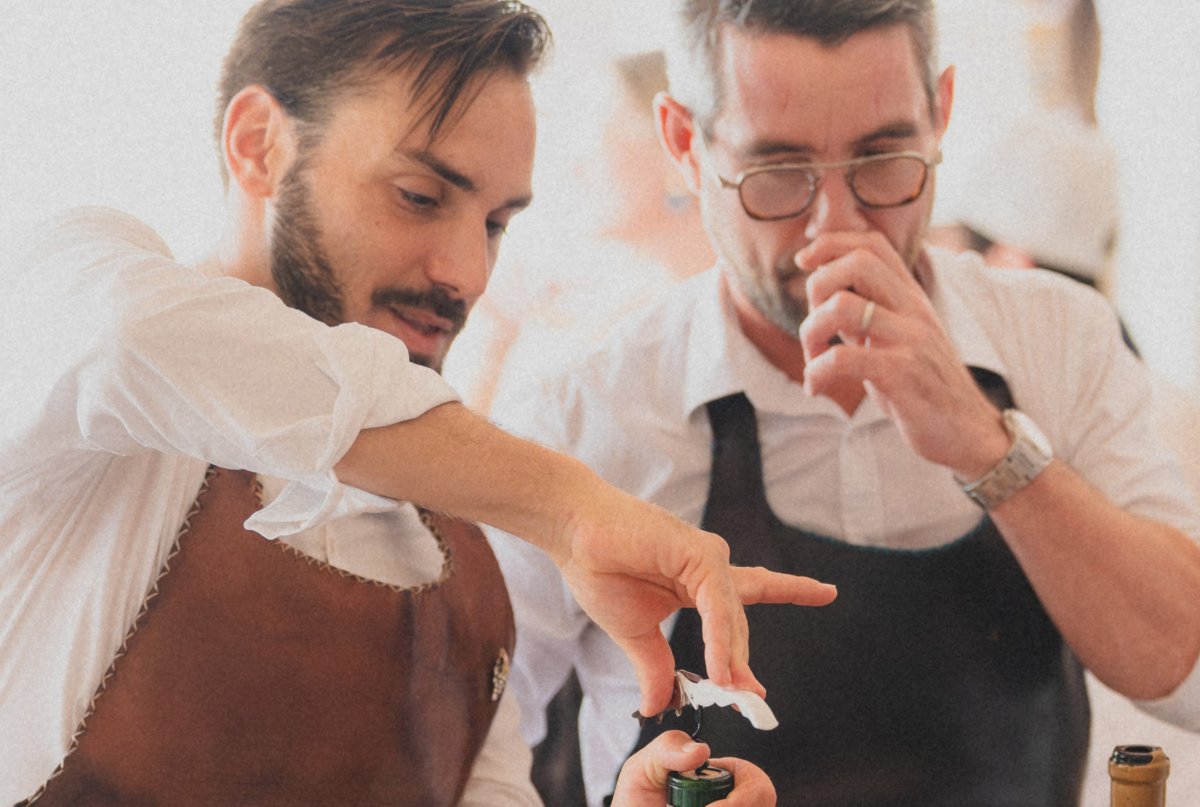 Waiters opening a magnum bottle of wine