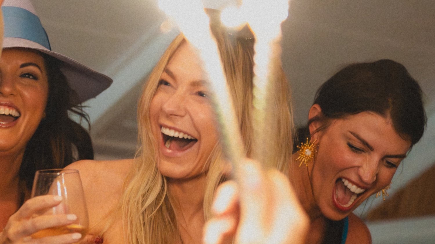 Women smiling and laughing while holding sparklers