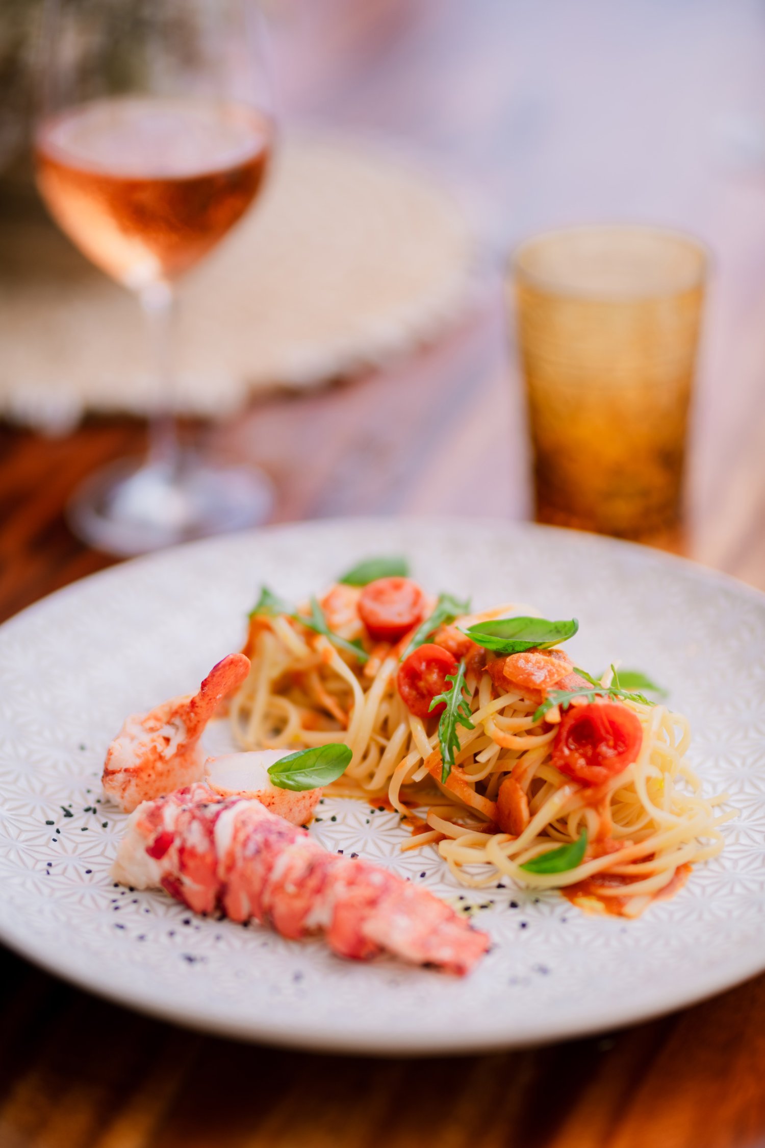 Small seafood pasta dish accompanied with a glass of wine