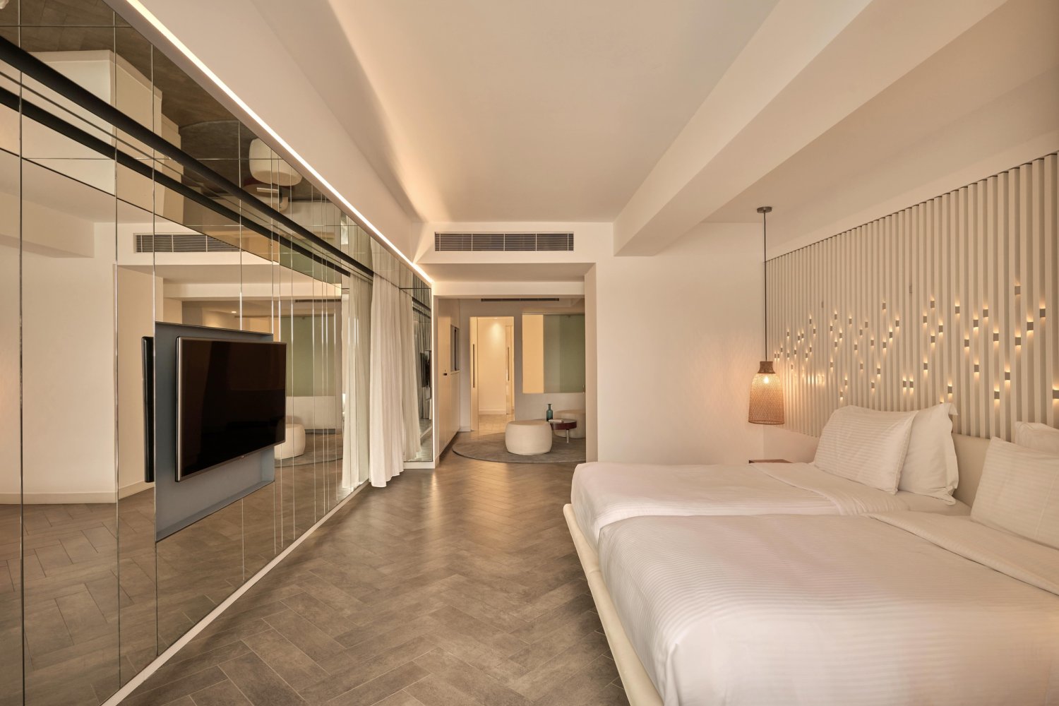 Elegant hotel room with a spacious bed and TV, offering a serene retreat and breathtaking views from the private balcony