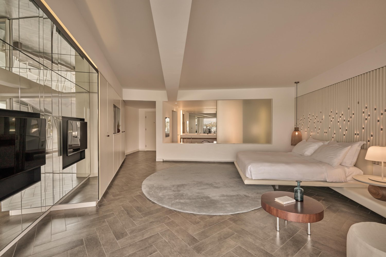 Elegant bedroom with a large, plush bed and a stylish television, perfect for unwinding after a day by the sea