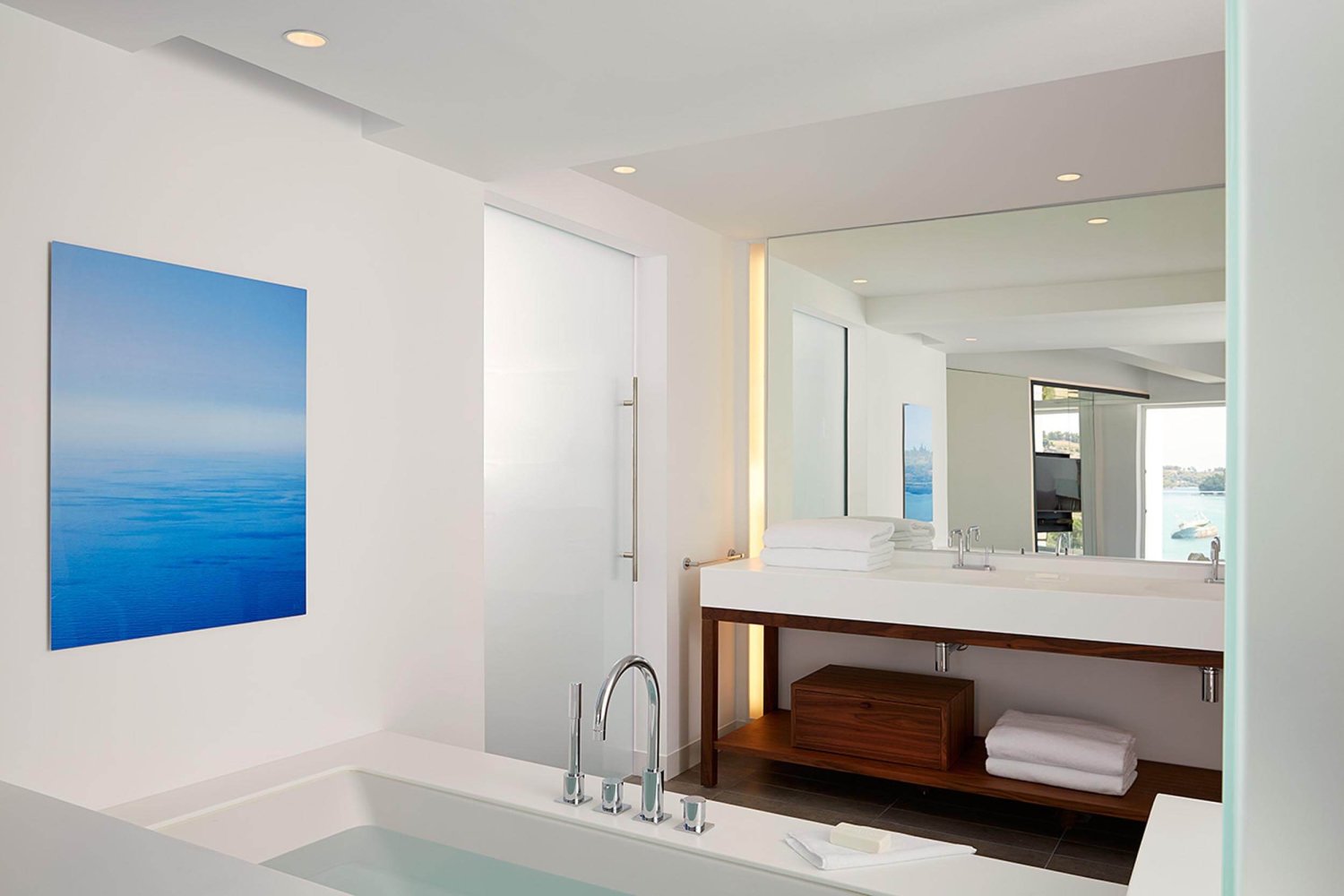 Bathroom with bathtub, sink and large wall mirror