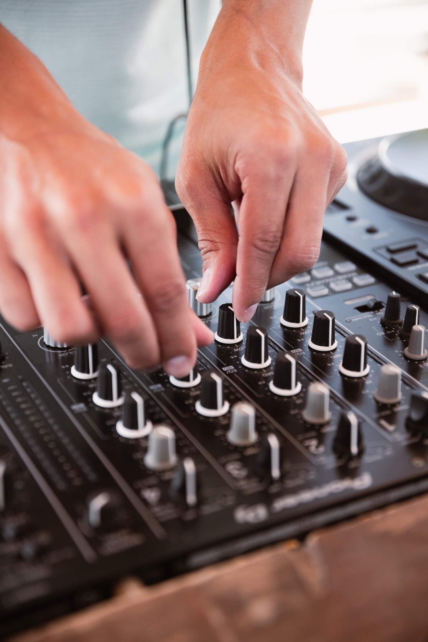 Close up of a DJ working on a DJ mixing board