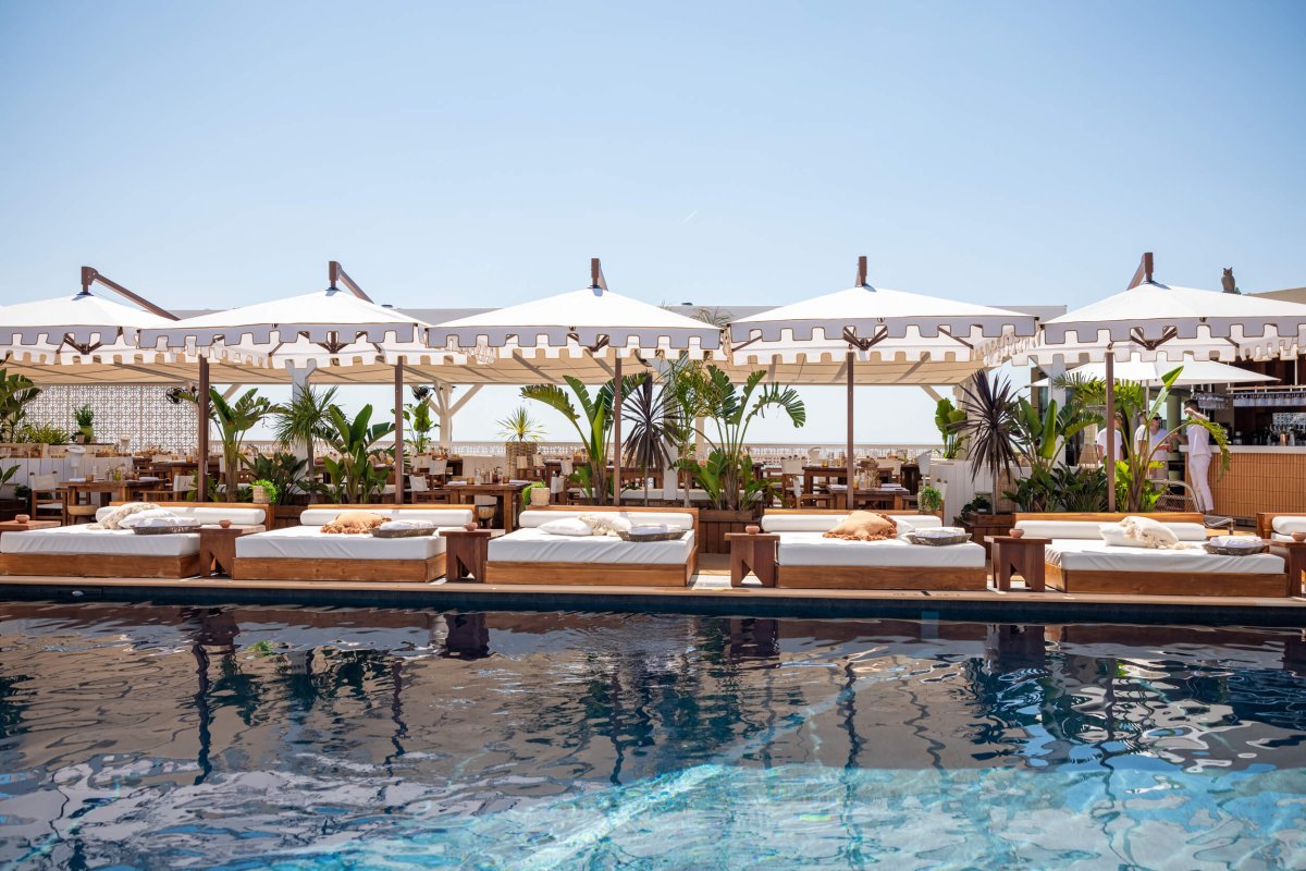 Sun beds with parasols at the side of a pool