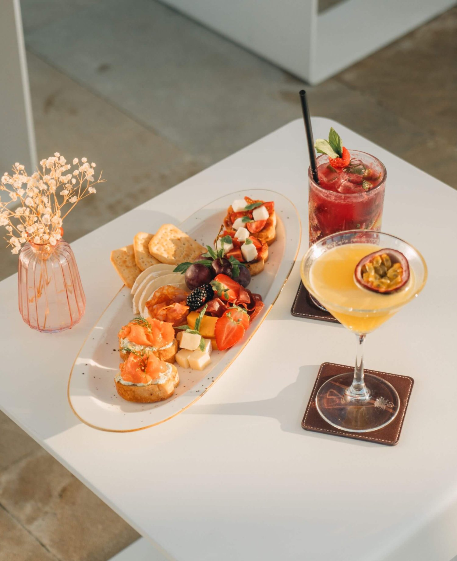An exquisite dining table adorned with two plates of vibrant dishes and stylish drinks, perfect for a luxurious meal