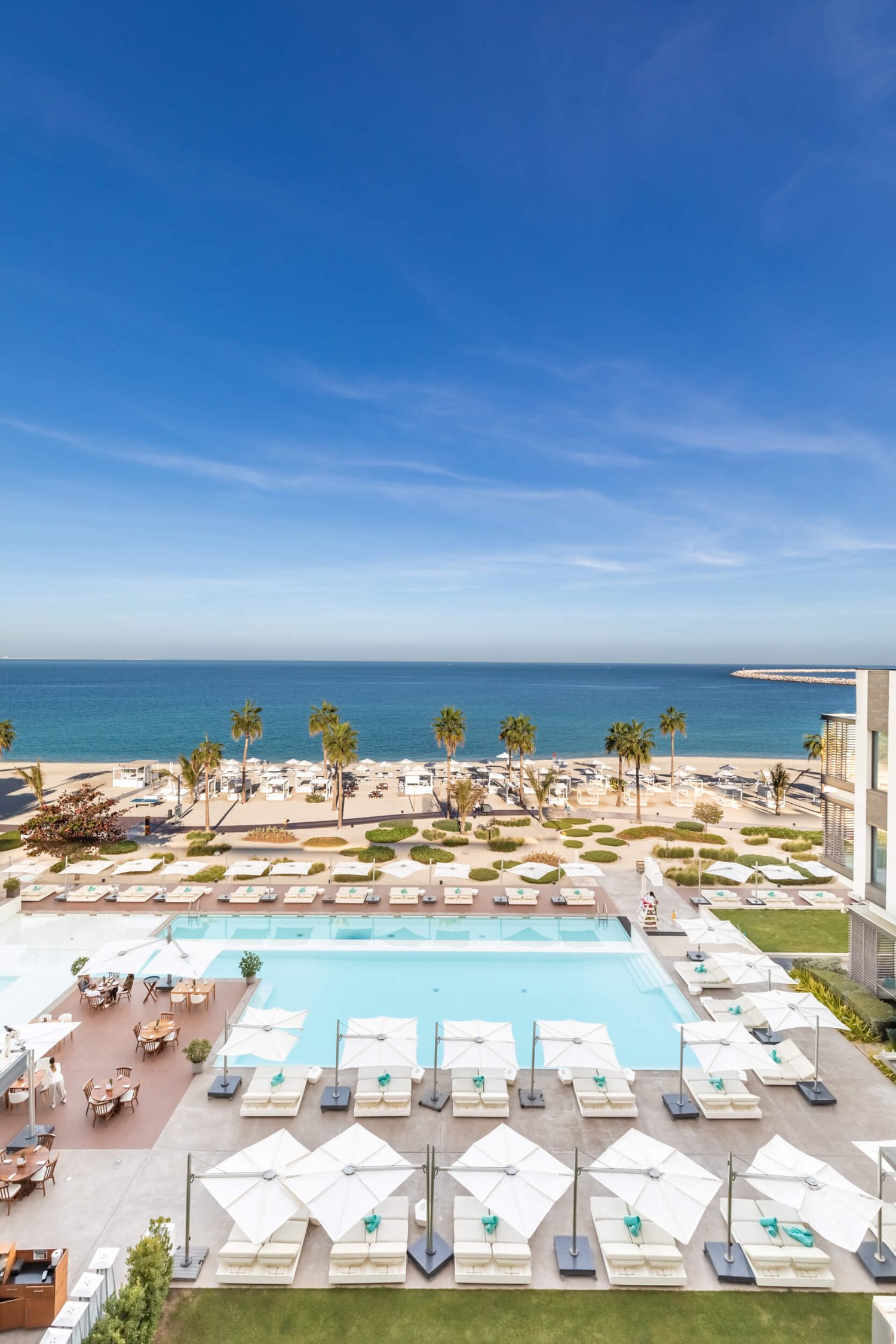 Nikki Beach Dubai Exterior showing the pool and beach areas with sun beds and umbrellas